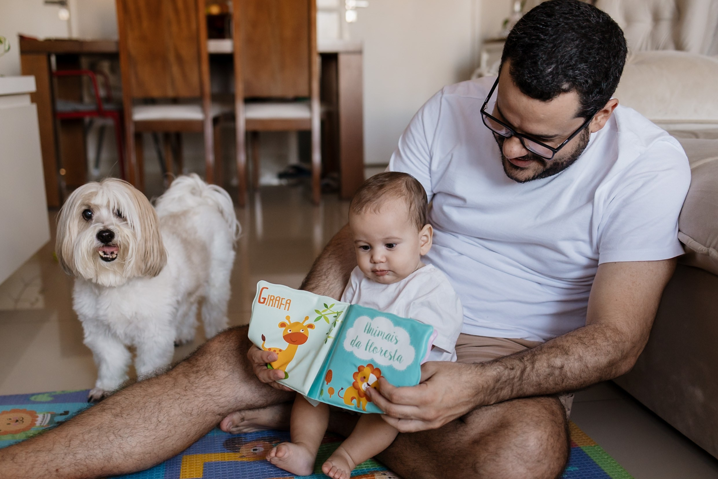 Pai e bebê com cachorro em casa