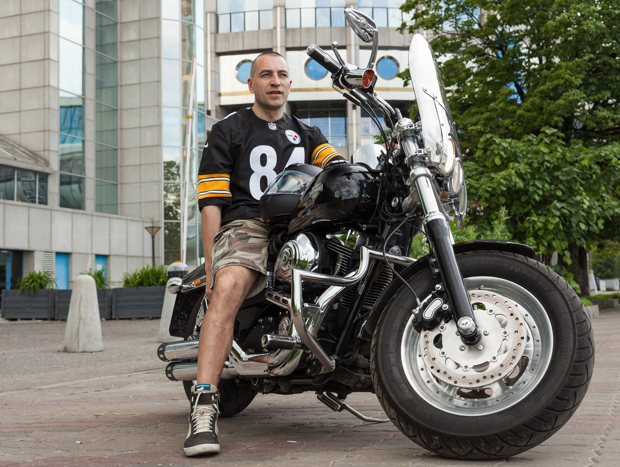 Location portrait of a biker on a Harley Davidson motorcycle in city landscape - photographer Andrey Dunin