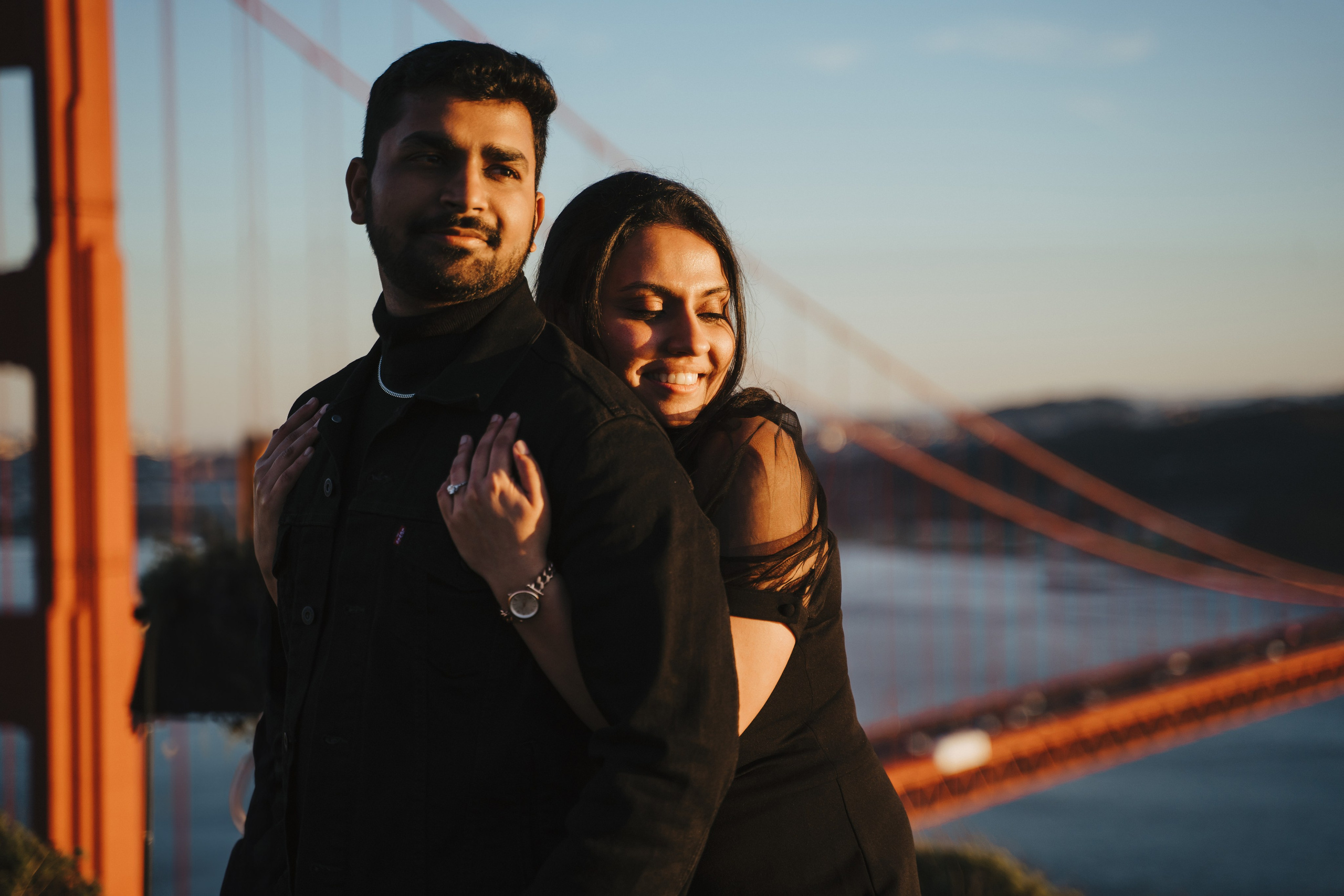 Proposal.  Overlooking the golden San Franisco Bridge sunset with a couple. Photographer Video. 