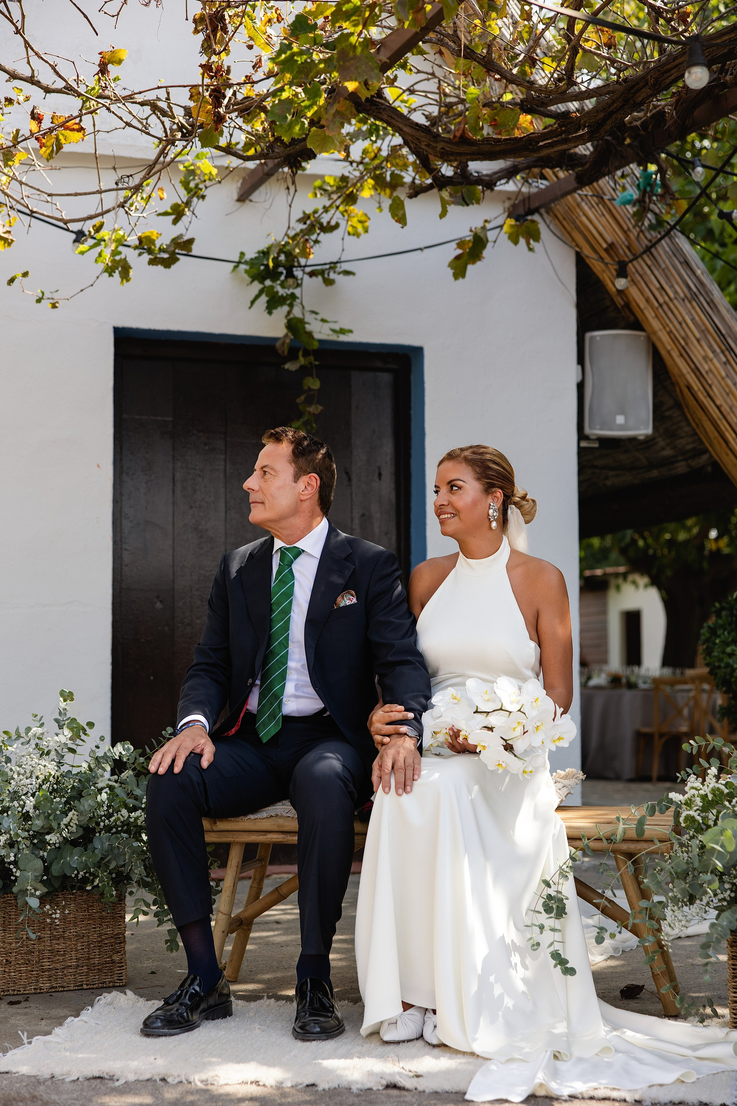 Los novios Ghislain y Miguel posando en la puerta blanca de la barraca, boda en El Palmar, Valencia