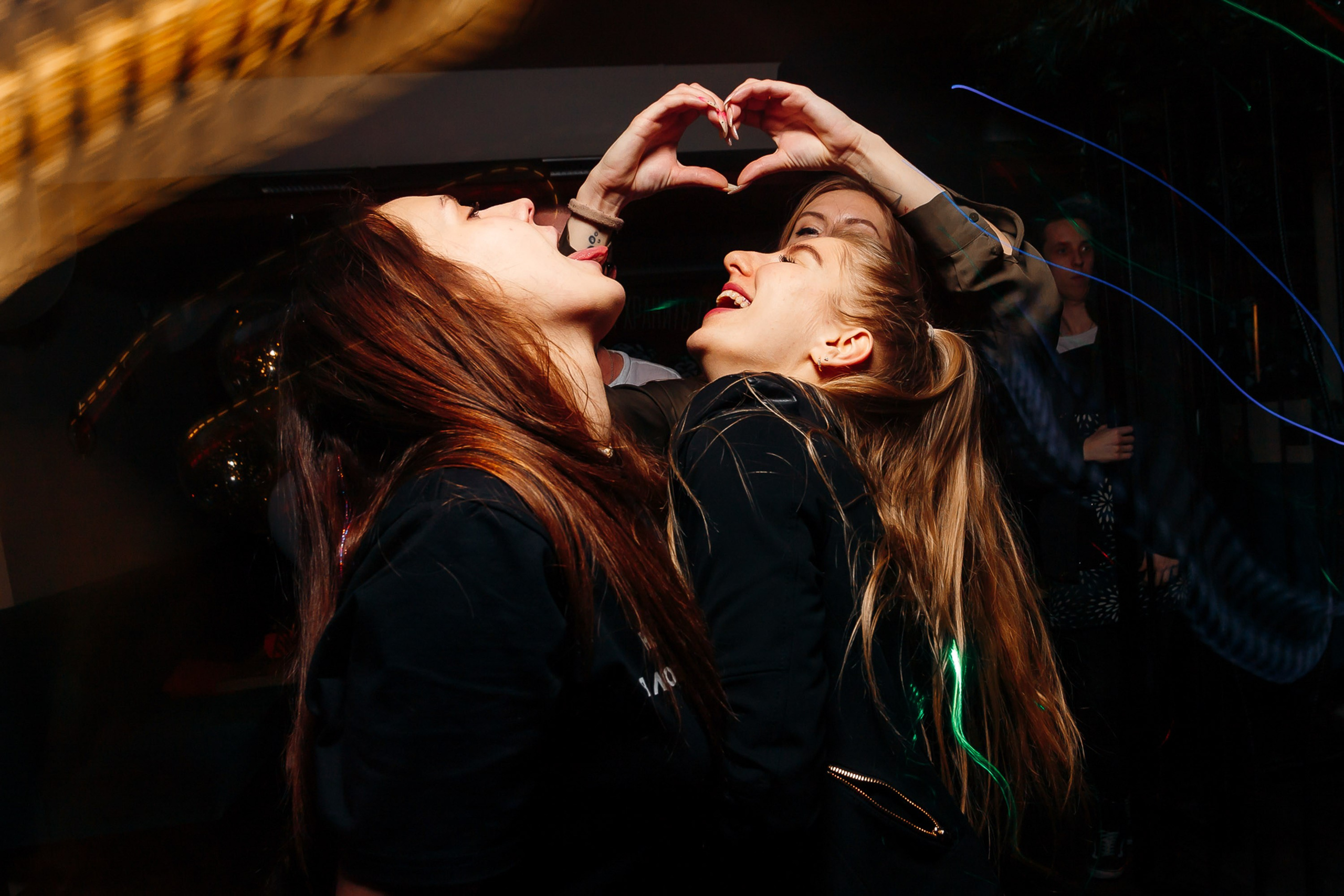 Woman dancing under lights at party, joyful vibe