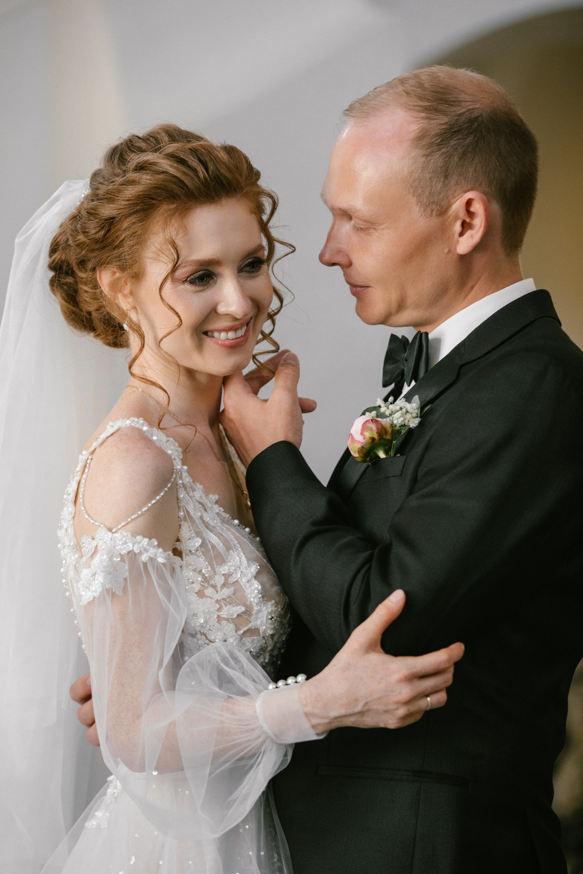 Braut lächelt, als Bräutigam zärtlich ihr Gesicht berührt – im Neuen Schloss Meersburg