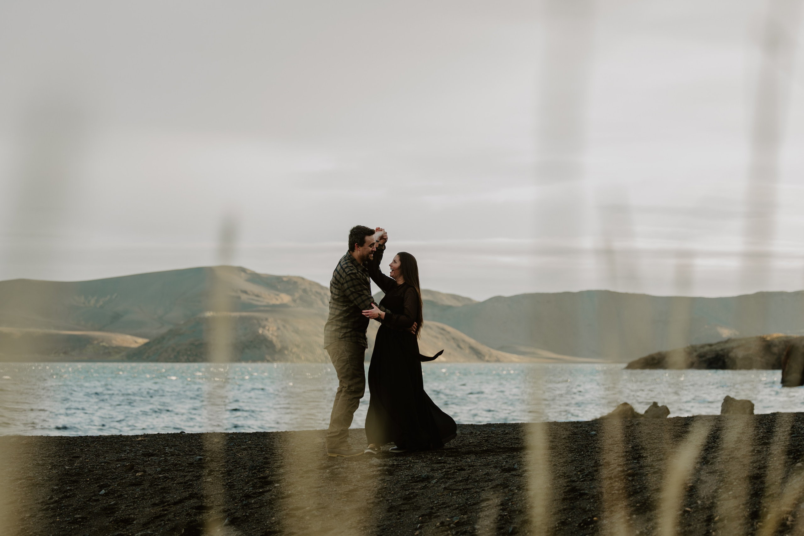 Romantic couple embracing, dancing in the stunning Icelandic landscape, captured during a scenic outdoor photoshoot