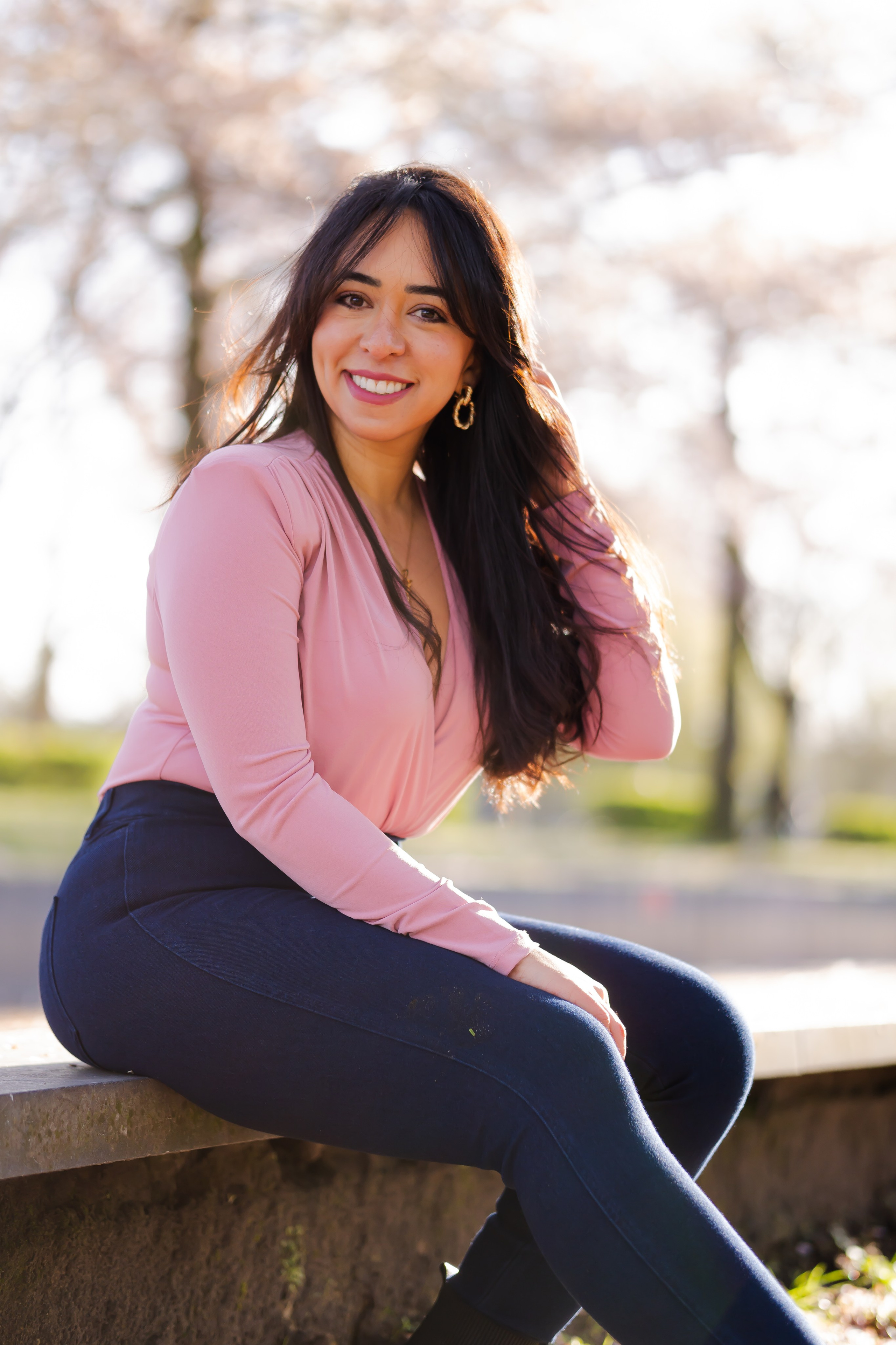 girl sitting in a cherry blossoms garden in Amsterdam