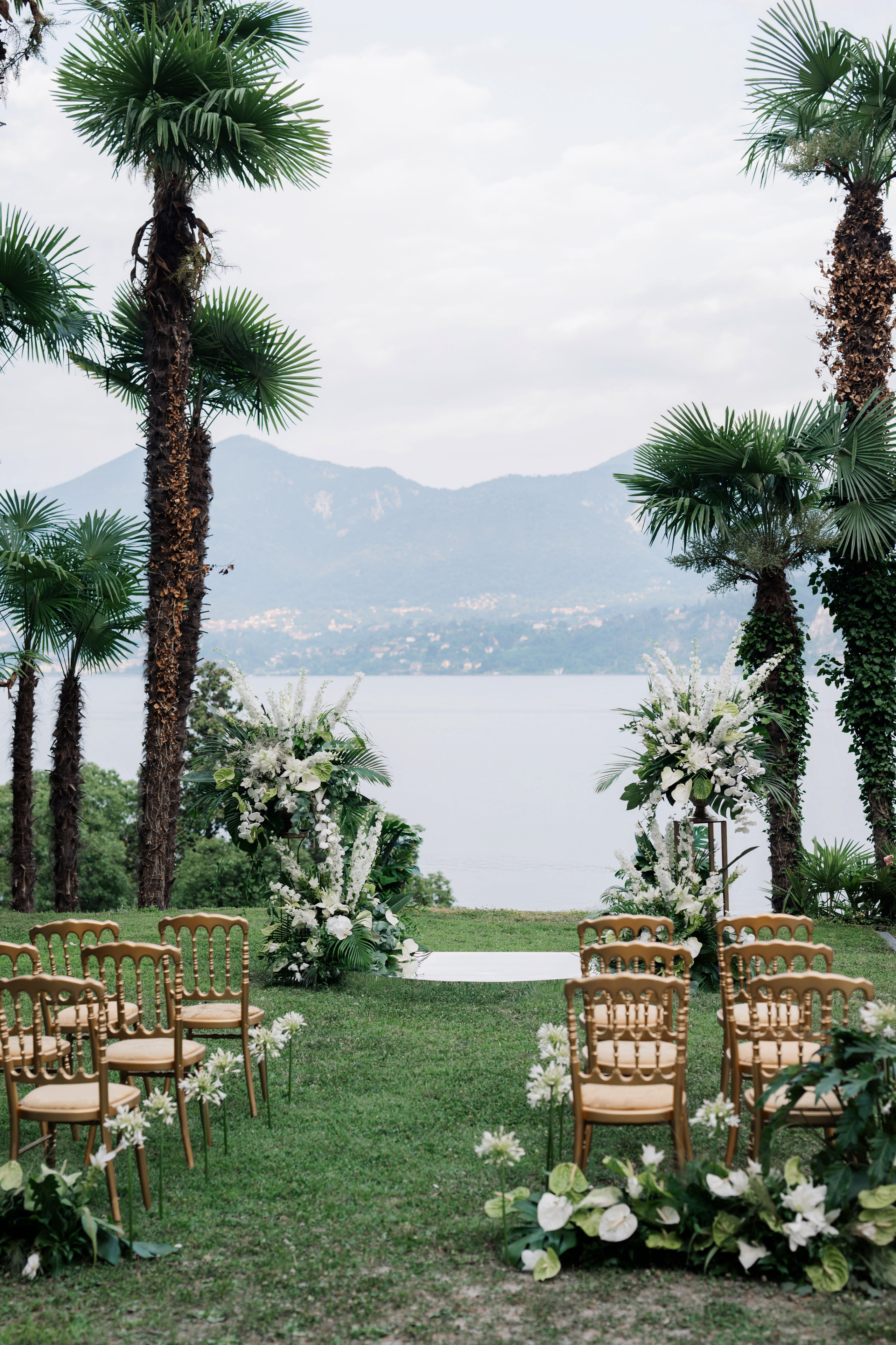 a wedding ceremony with palm trees and chairs