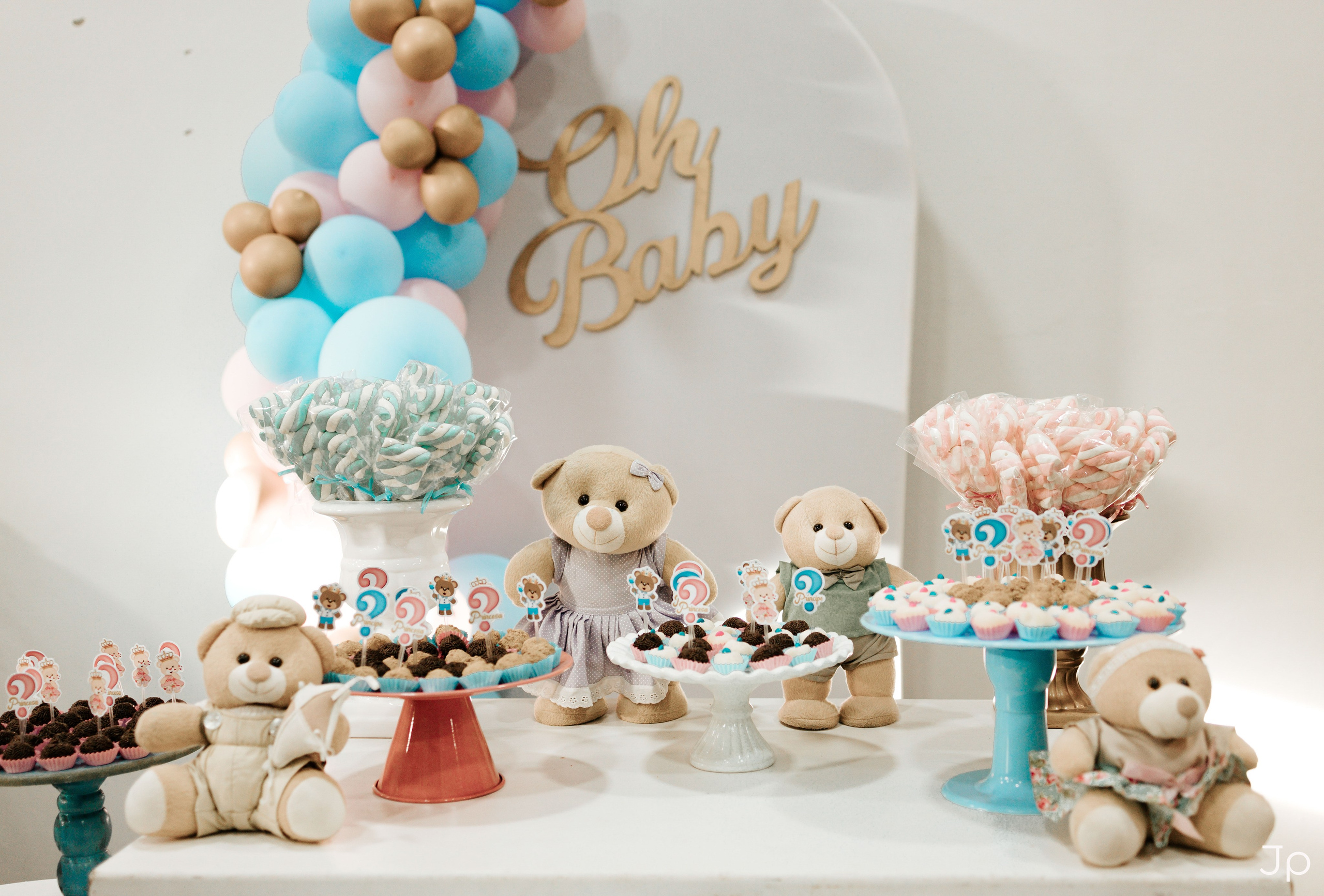 Mesa completa do chá revelação com bolo, doces e balões.