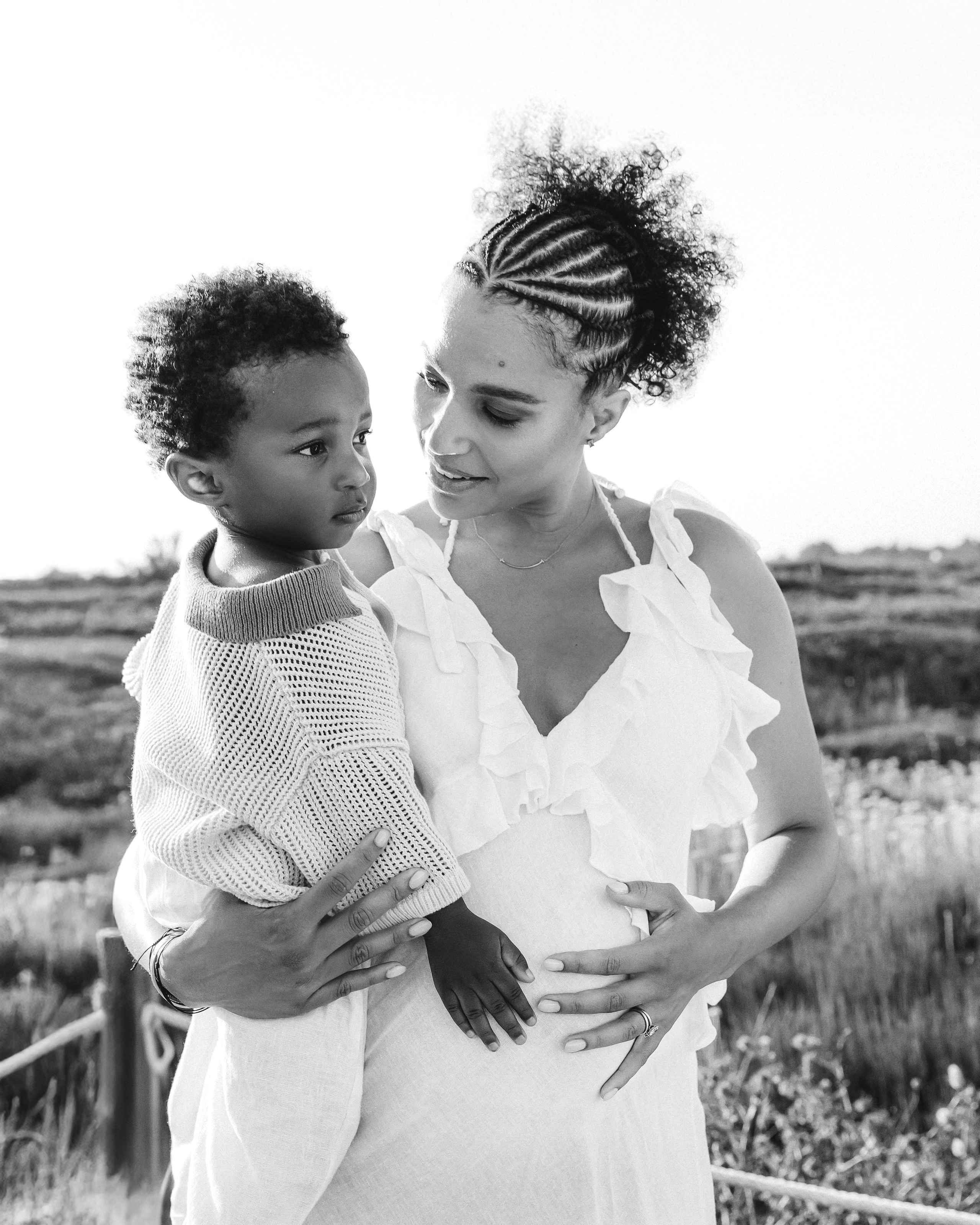 Emotivo retrato de madre e hijo en Alicante, España — foto en blanco y negro de una madre abrazando tiernamente a su hijo al aire libre, mostrando amor, ternura y conexión familiar.