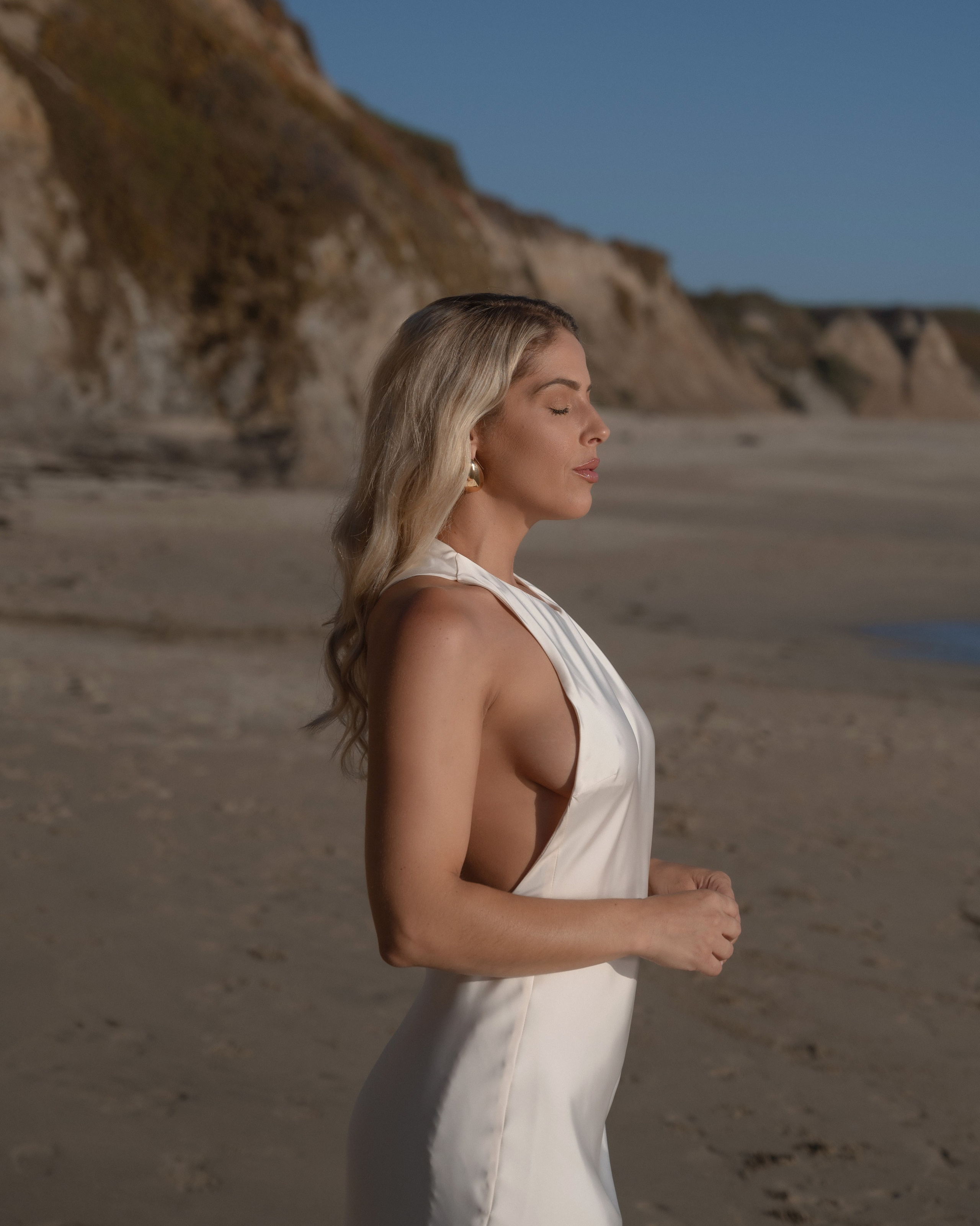 Woman in a summer dress, sunset light on the beach, model photoshoot for portfolio