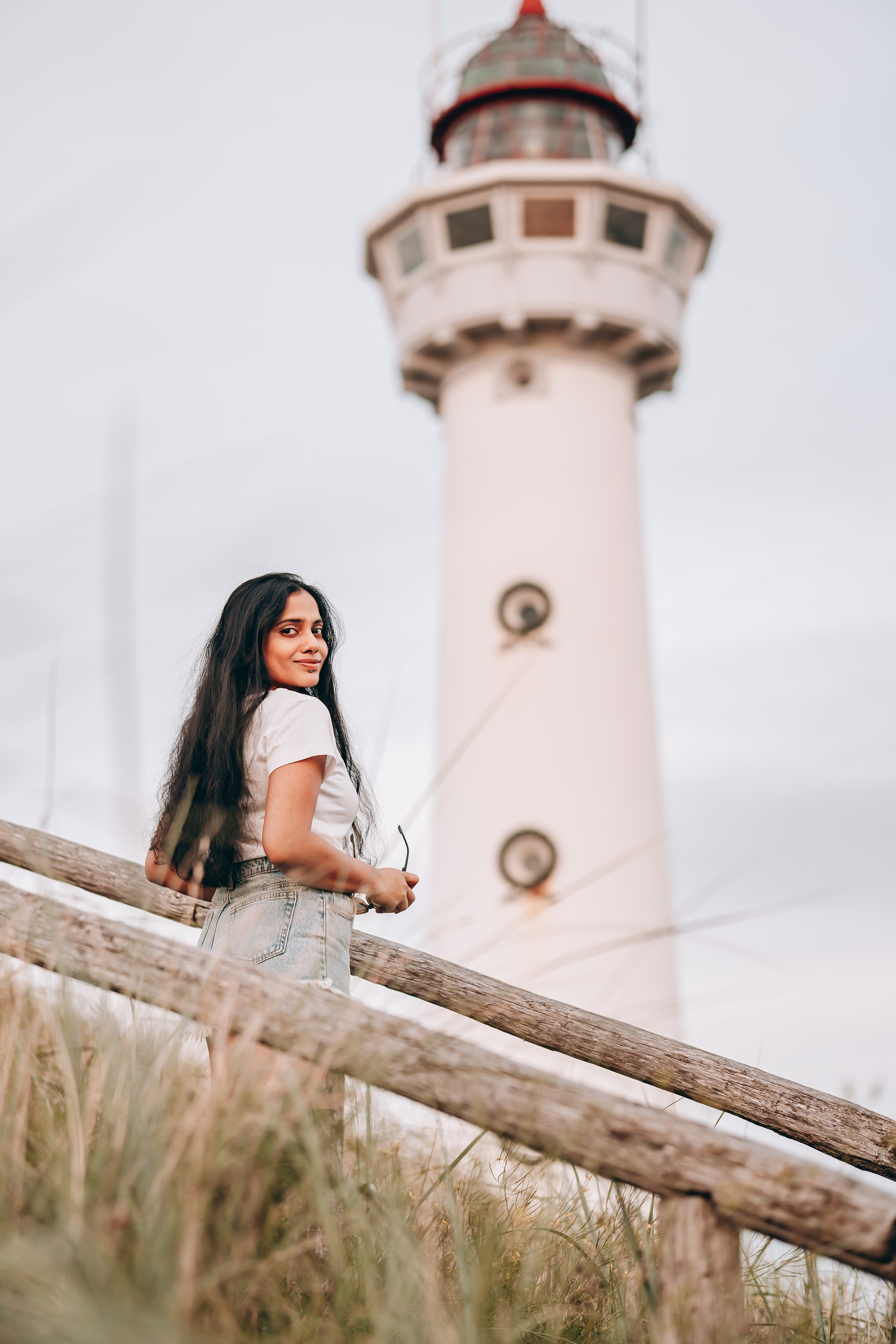 Woman standing in front of a lighthouse in the Netherlands