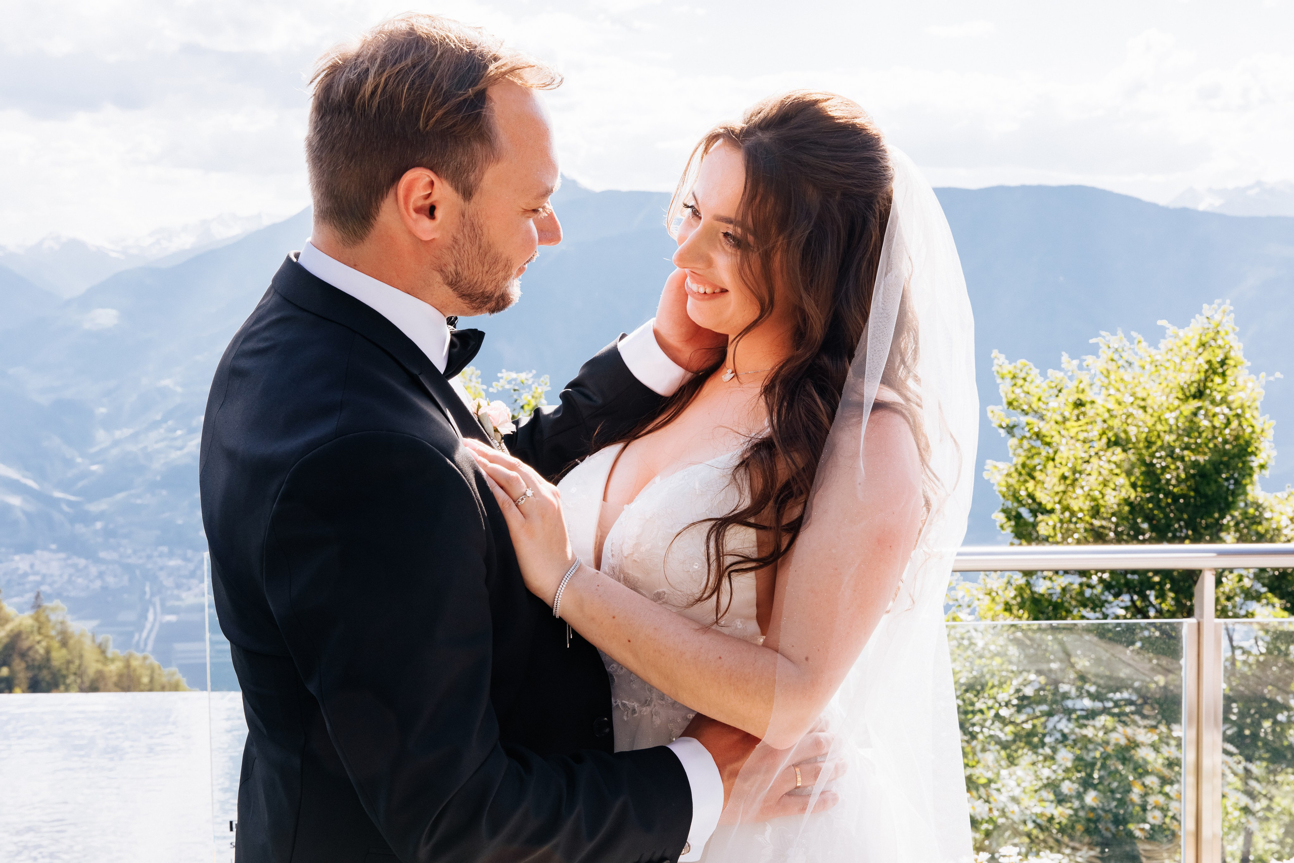 Bräutigam streichelt liebevoll das Gesicht der Braut – ein romantischer Moment voller Zärtlichkeit.