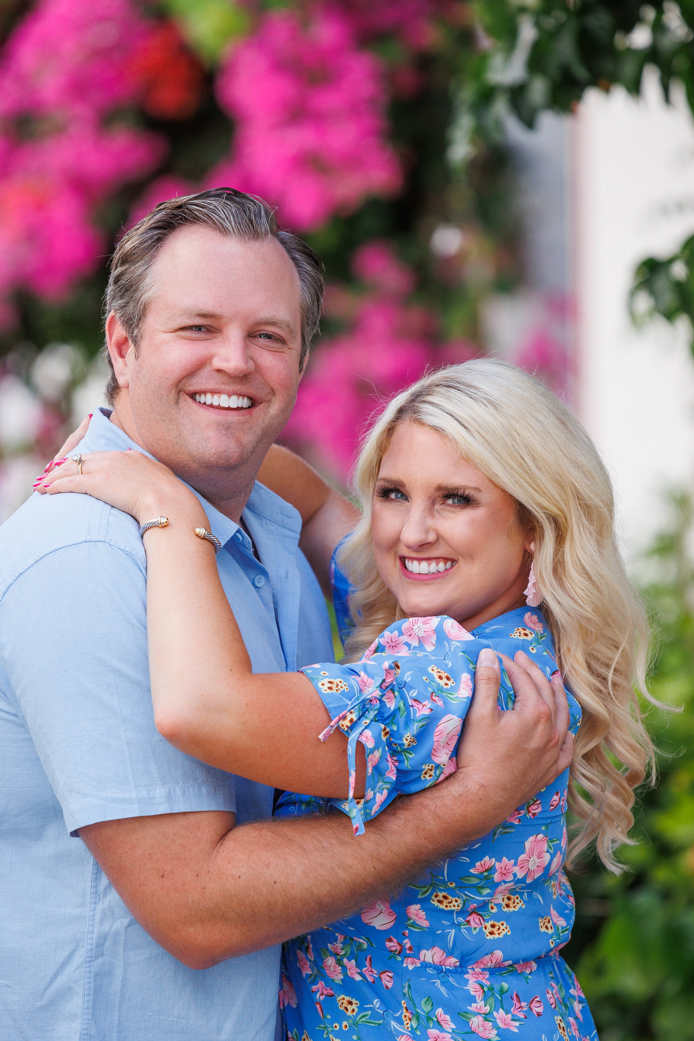 A couple embracing in front of flowers in Puerto de Mogan, captured by the photographer's photo shoot