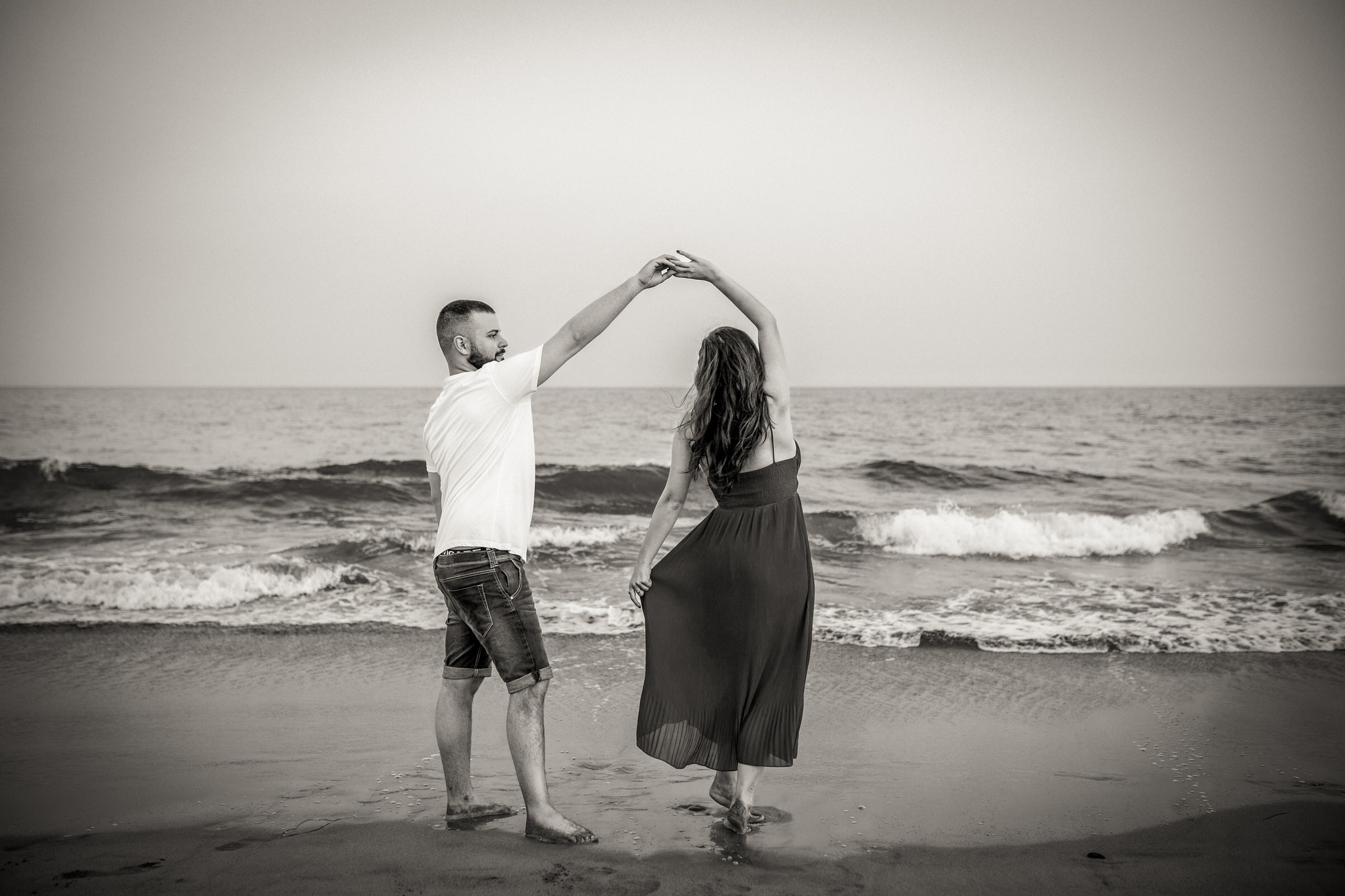 Cherished Moments: Love Story in Gran Canaria A black-and-white photo of a couple holding hands on the beach
