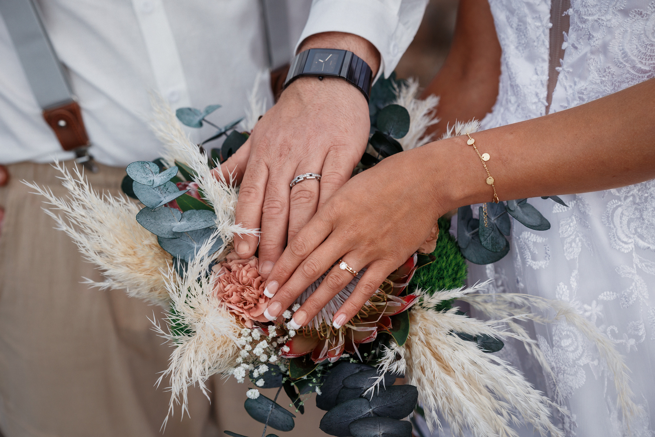 Photo shoot The hands of a bride and groom holding a bouquet