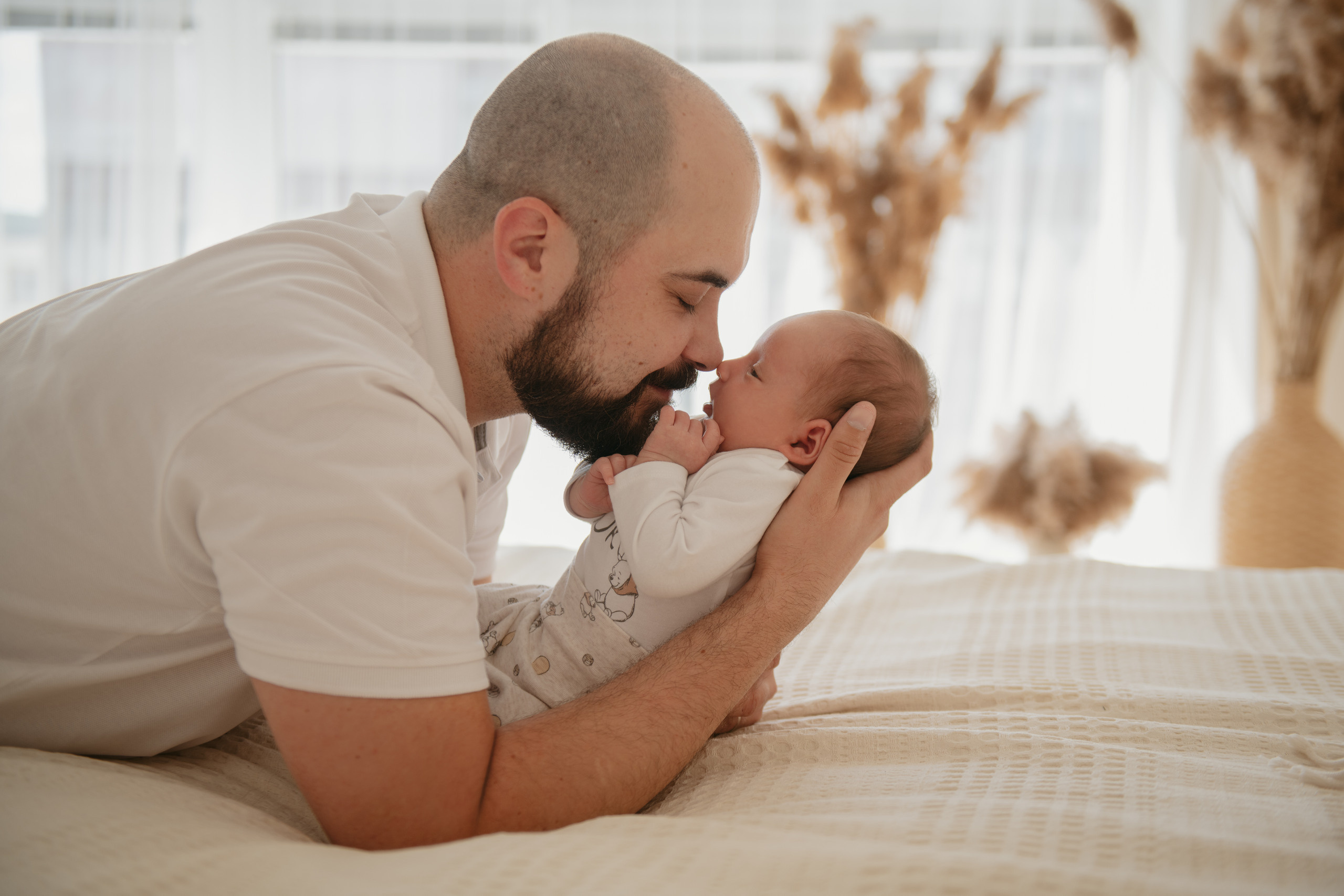 Папа держит на руках своего маленького спящего сына