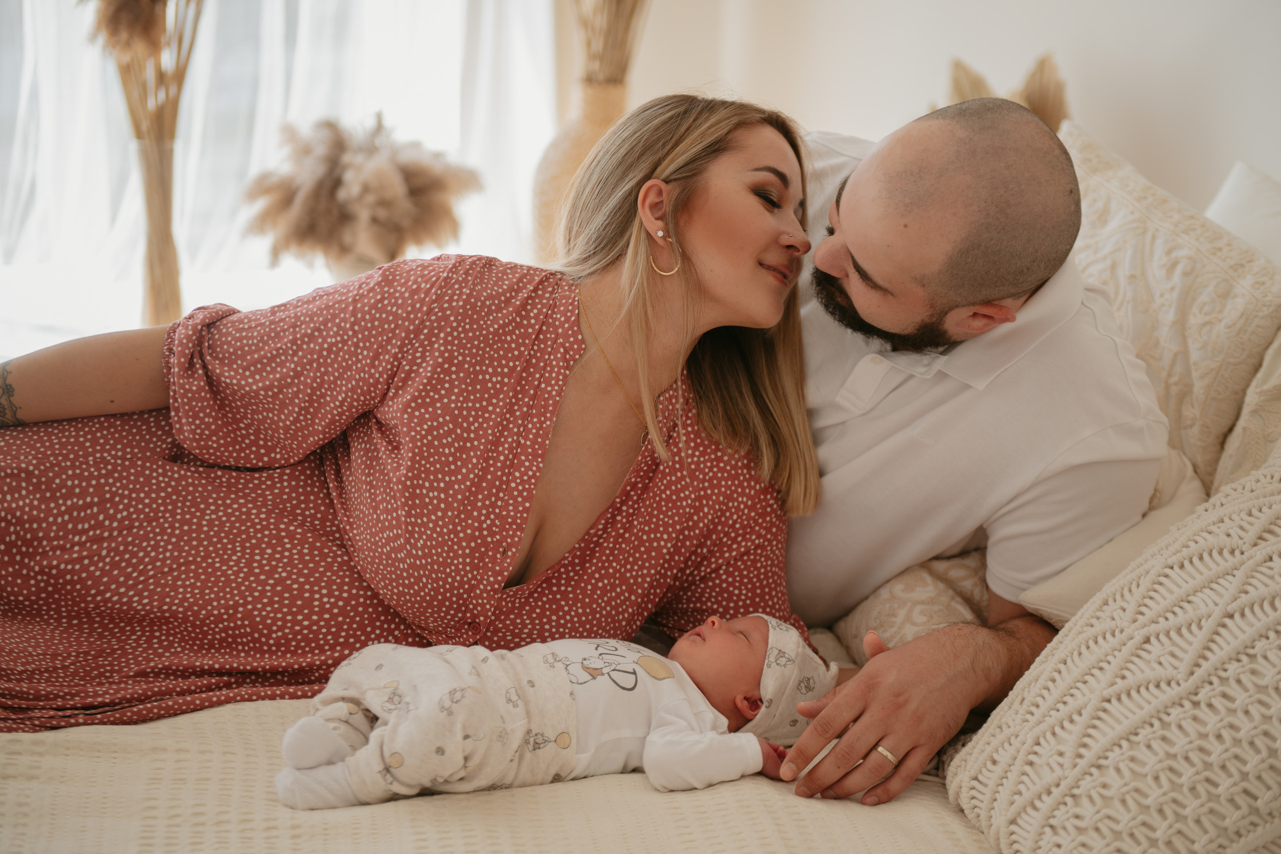 Мама и папа лежат рядом со своим новорожденным малышом