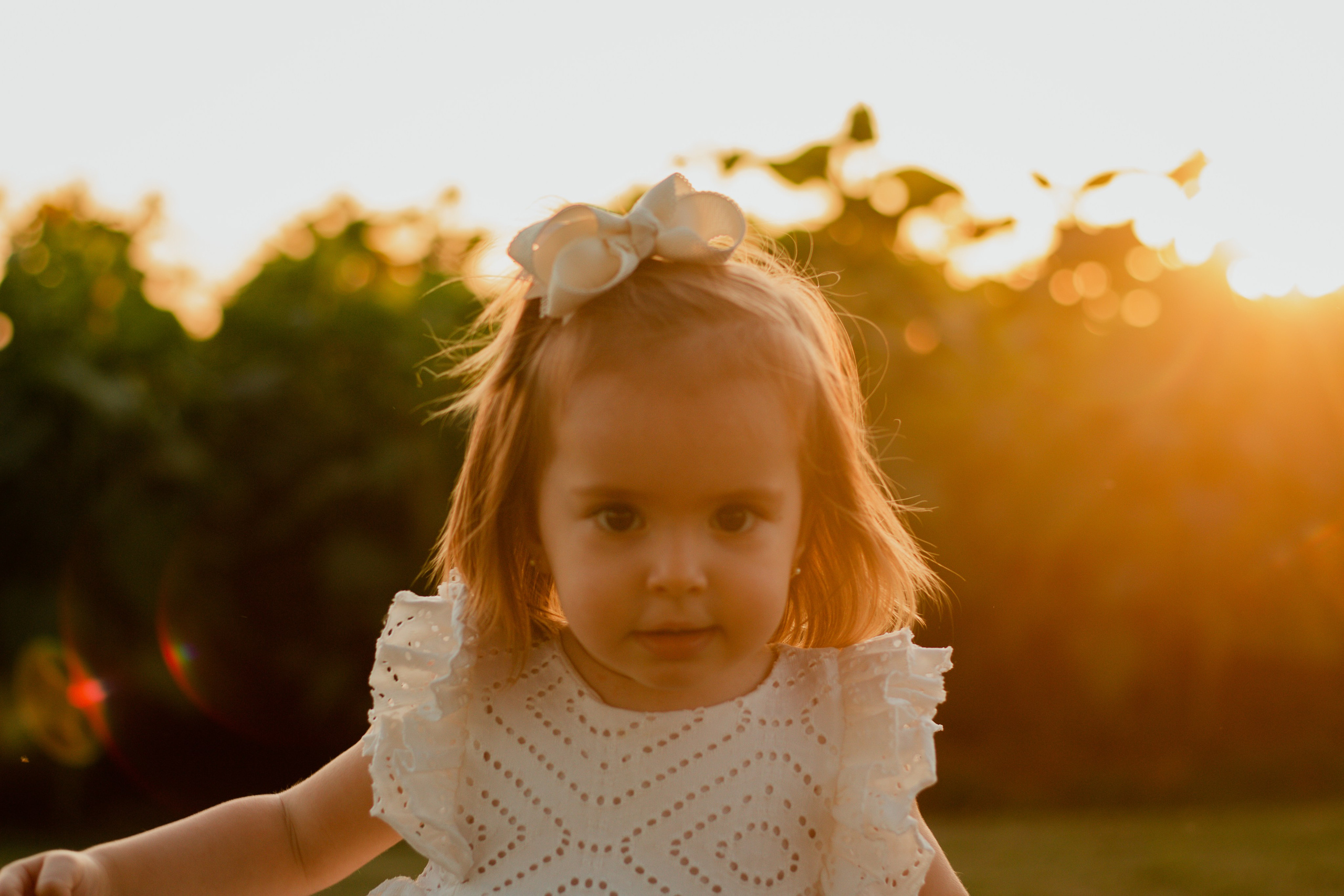 Menina sozinha em meio aos girassóis ao pôr do sol em Holambra, registrada em momento espontâneo e iluminado.