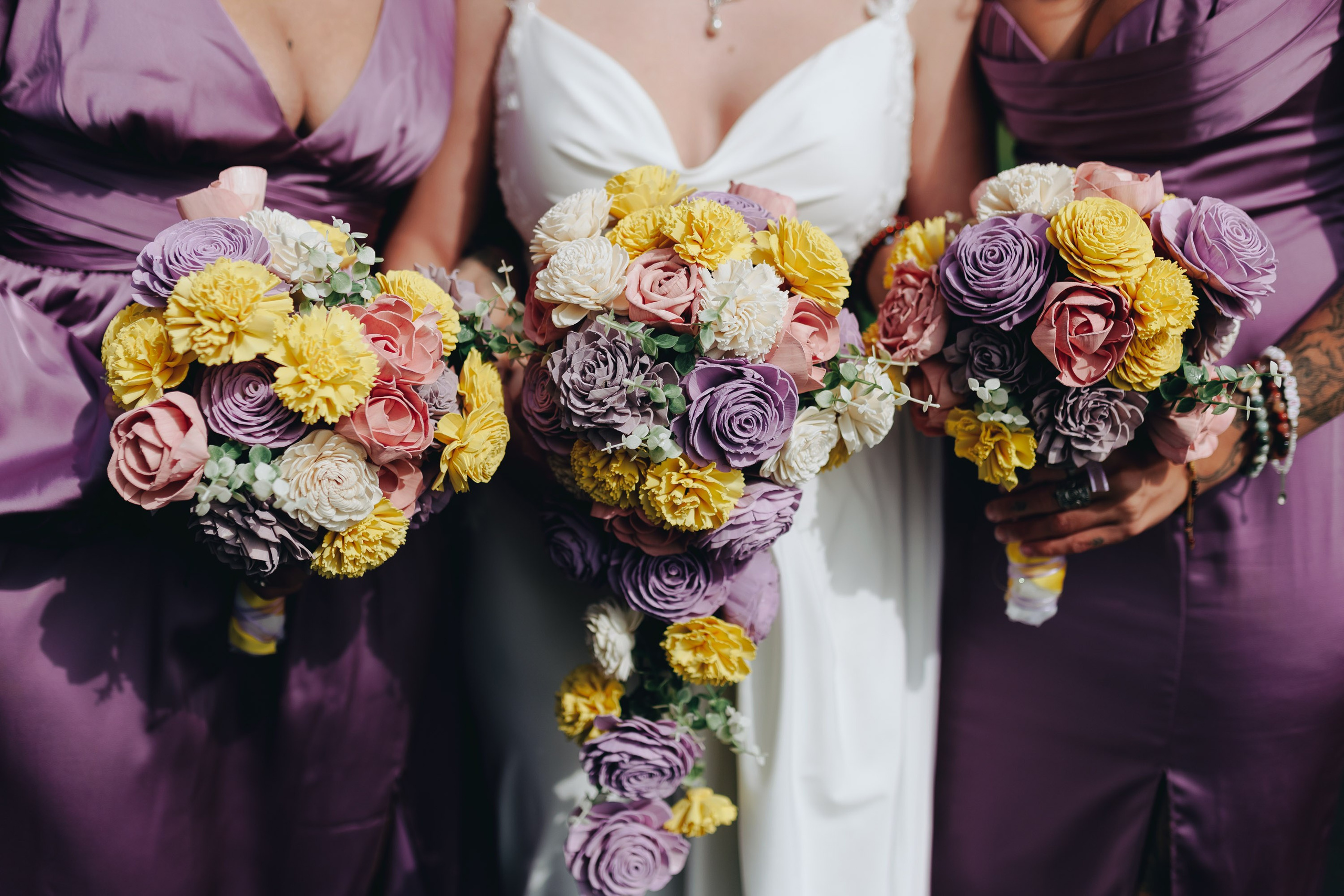 Bridesmaids holding colorful bouquets, wedding details