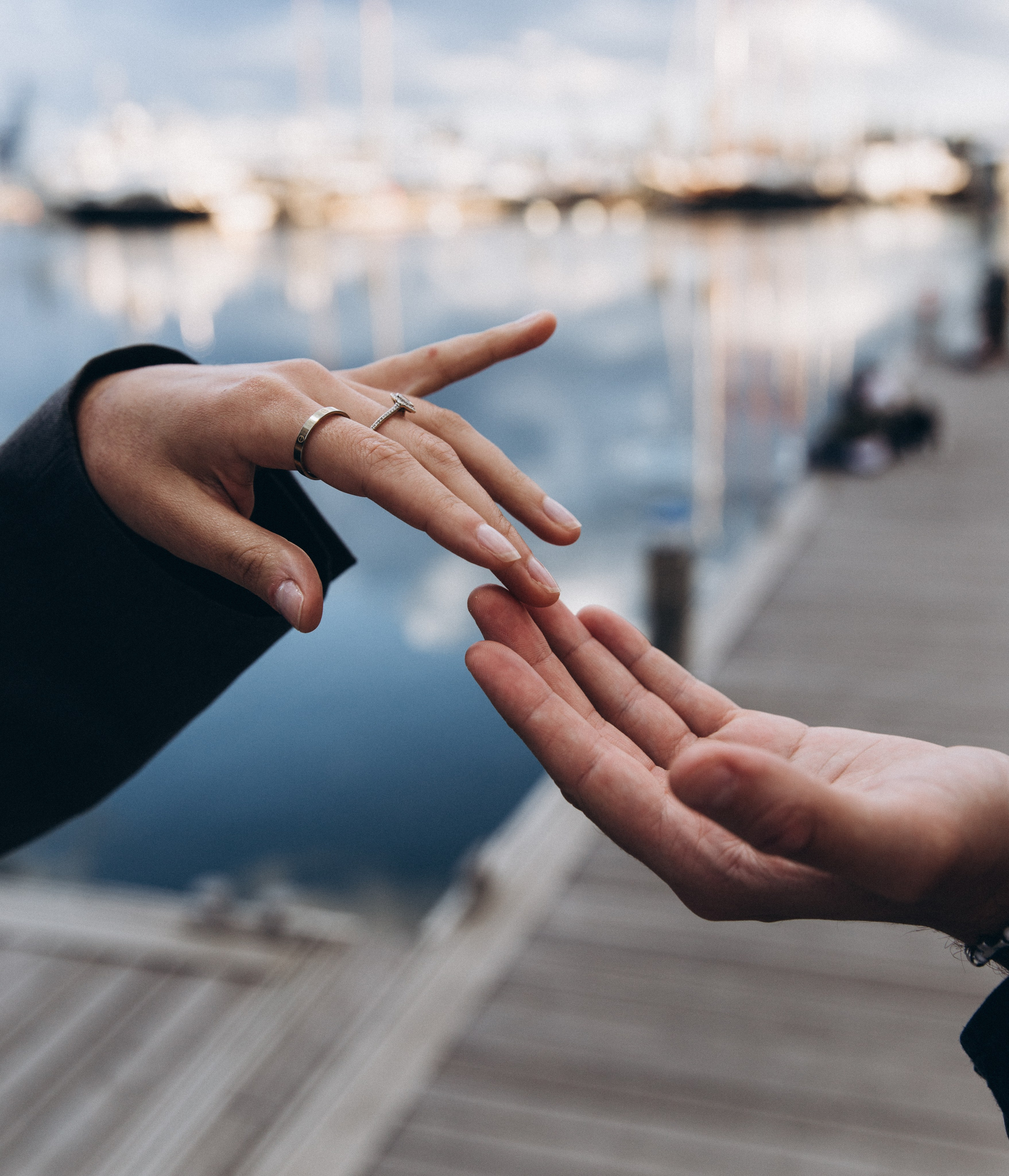 Romantic close-up of a couple’s hands reaching for each other at the marina in Valencia, Spain — symbolic and artistic love story photography capturing connection, emotion, and the essence of intimacy, perfect for couple photoshoots in Valencia and across Spain.