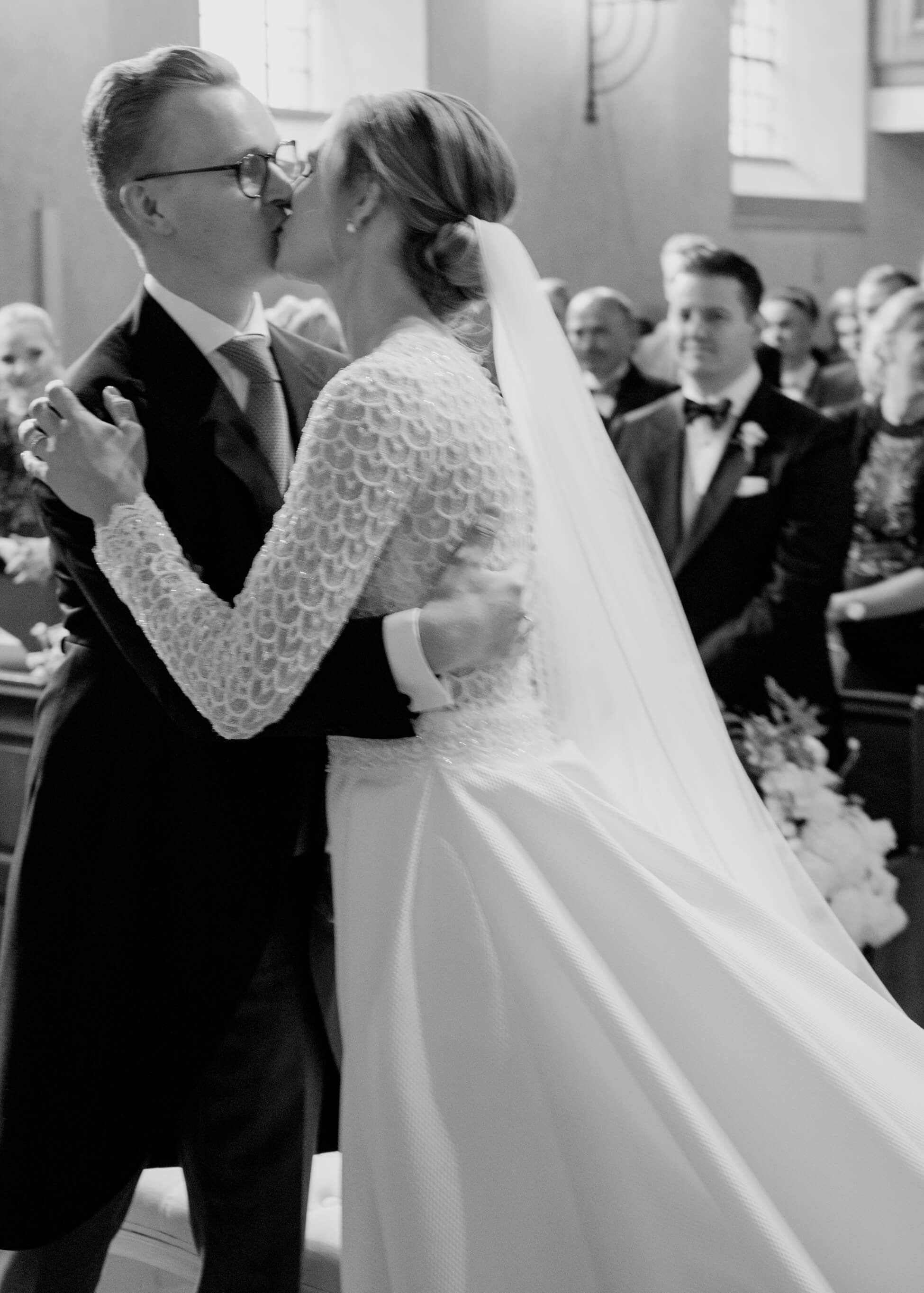 Bride and groom first kiss at church altar during ceremony, luxury wedding photographer Frankfurt