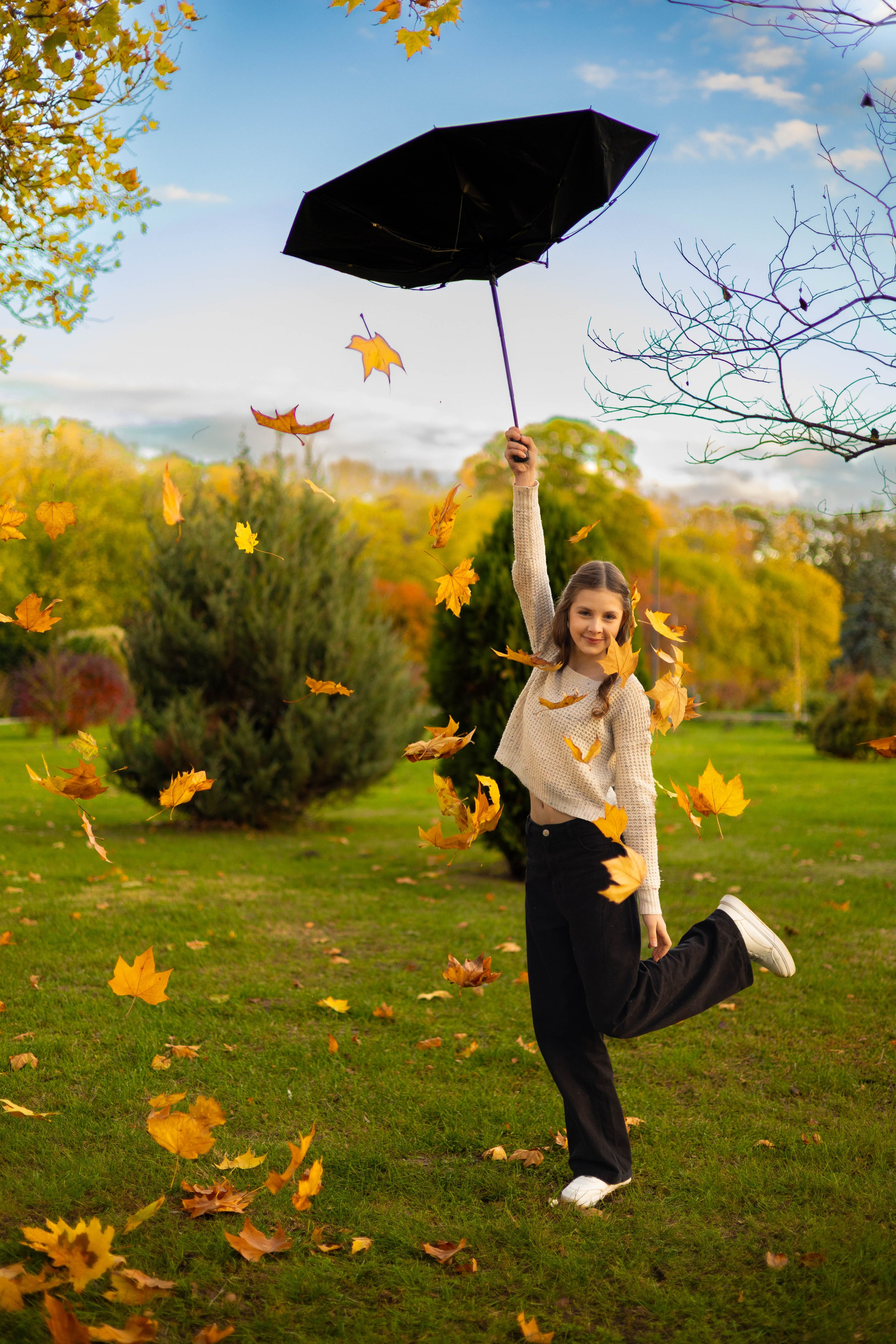 Девушка улыбается, стоя под падающими осенними листьями.