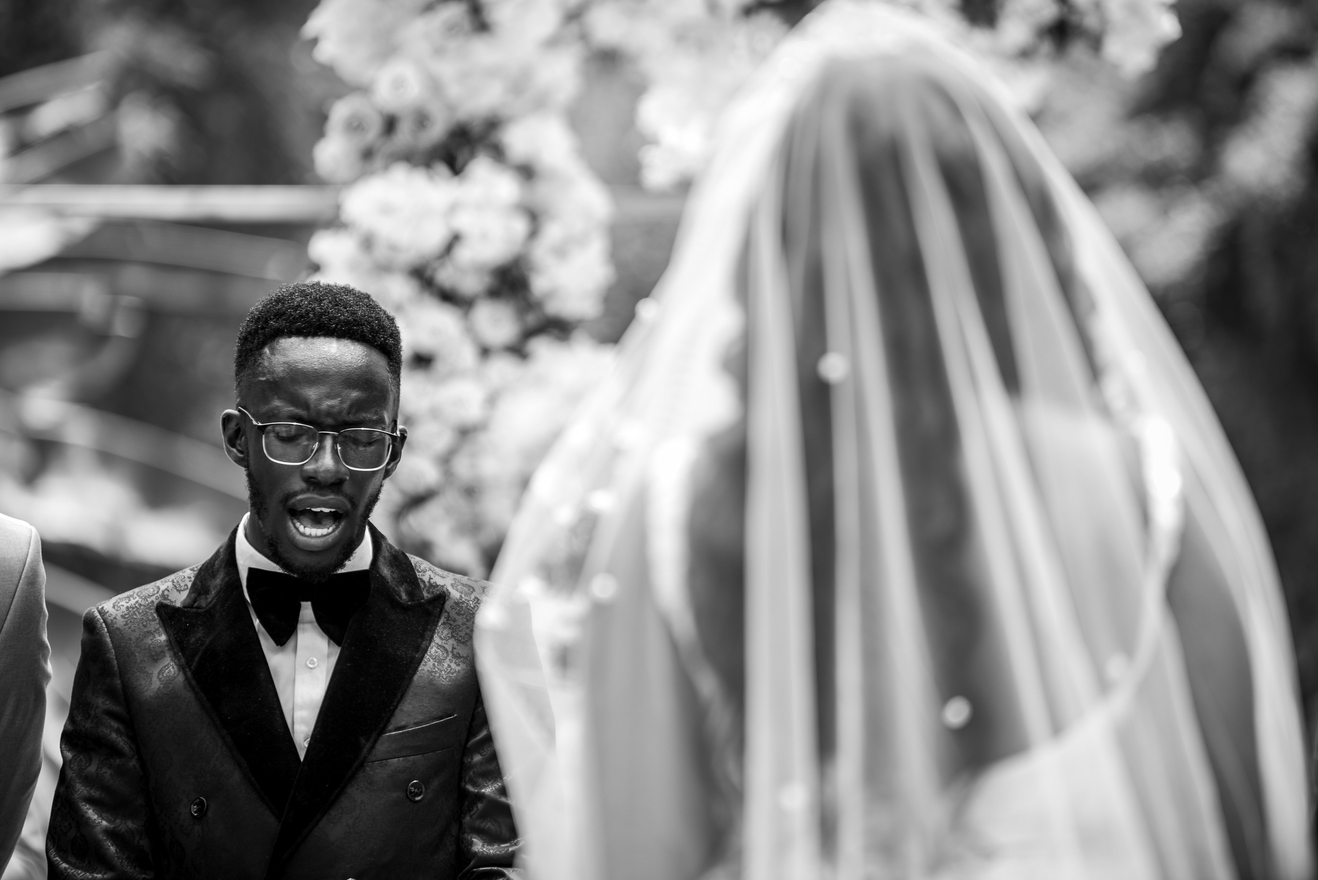 Black and white portrait of a Groom singing at the church ceremony