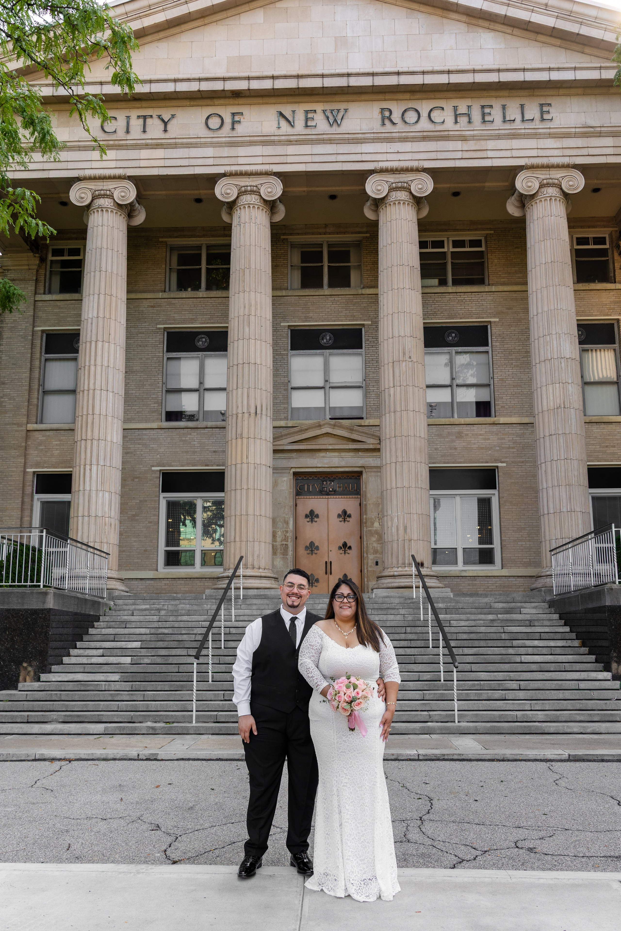 Newly married couple posing on the historic steps of New Rochelle City Hall