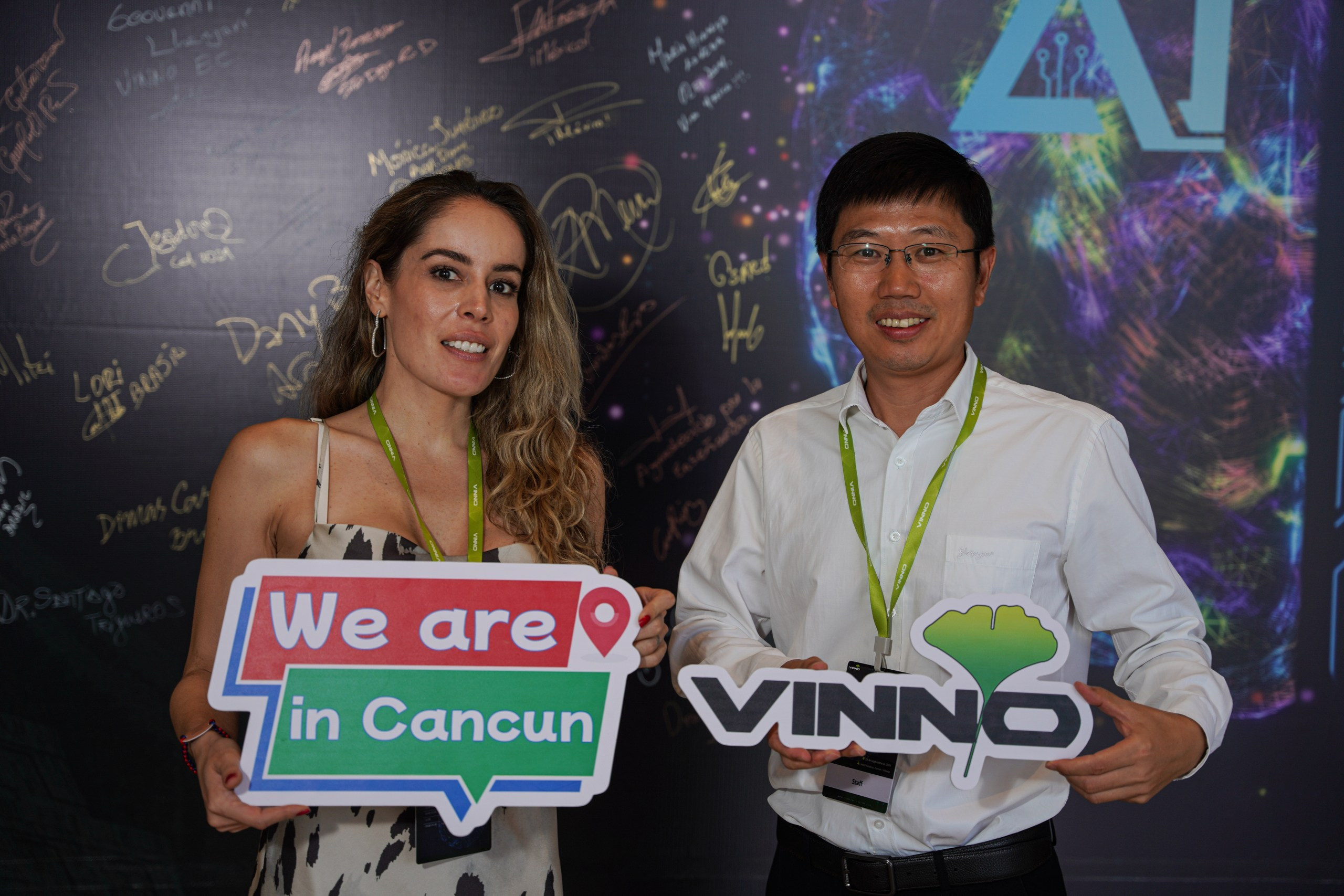 Participant photographed near event branding wall.