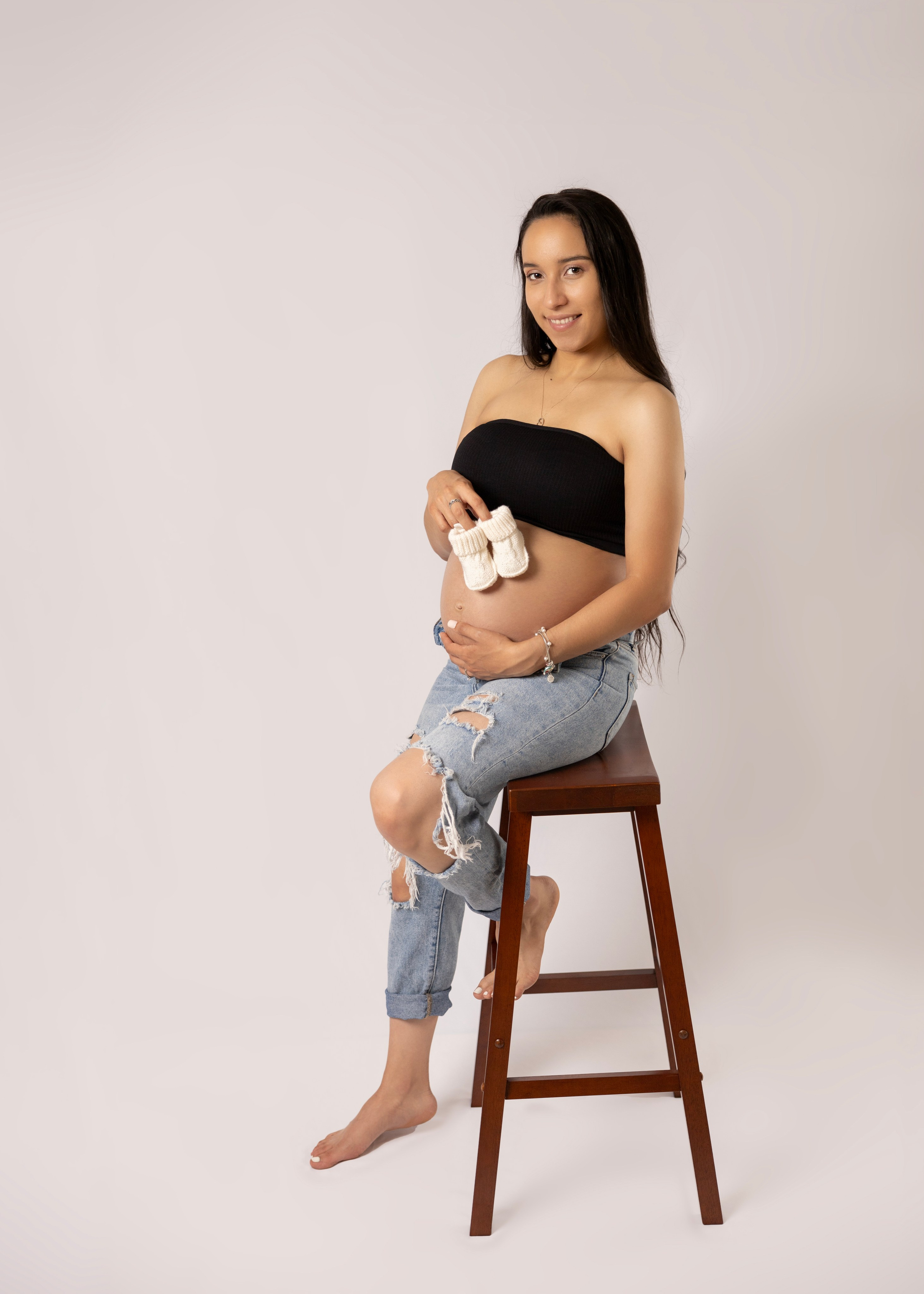 studio maternity photoshoot, woman siting in the high chair