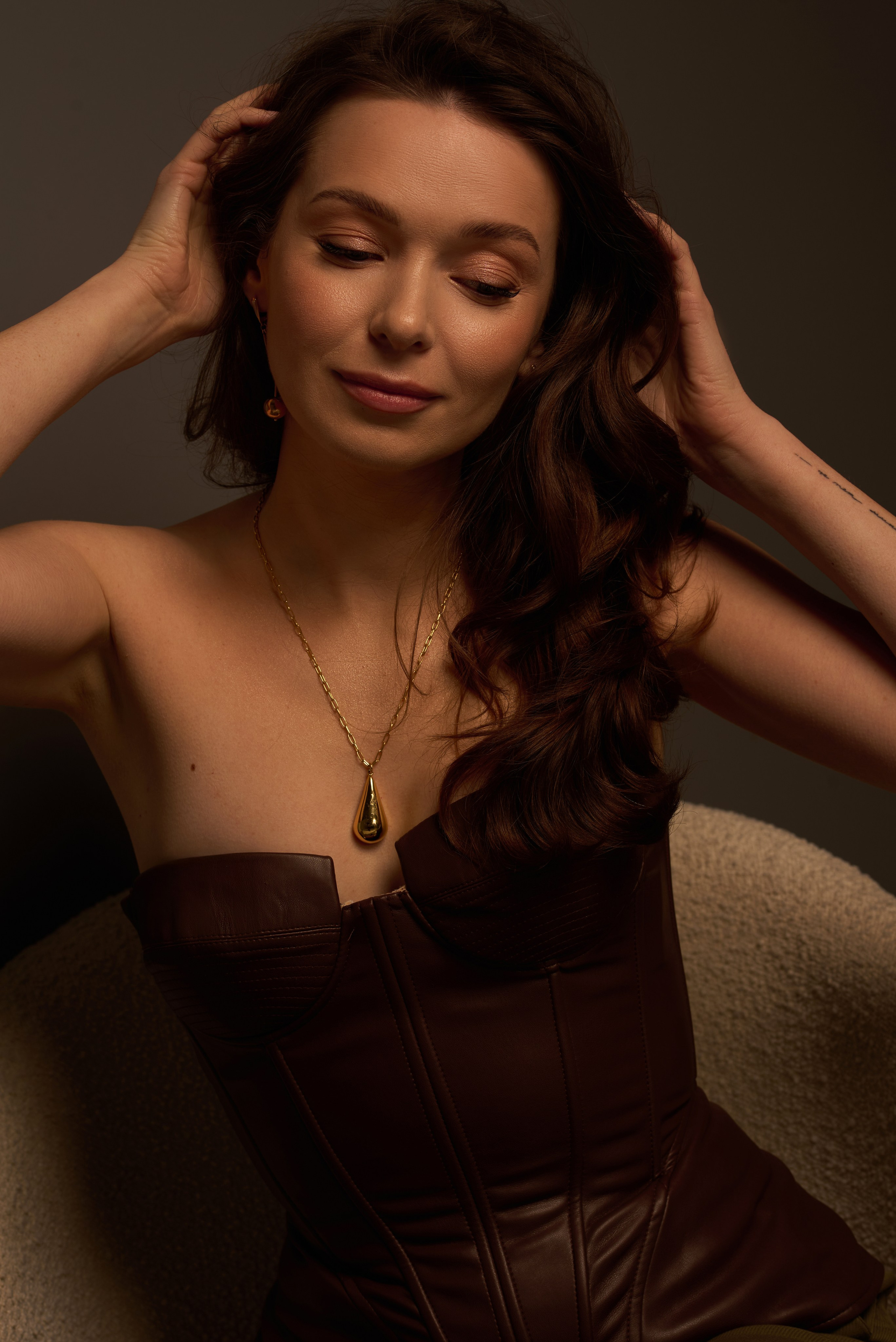 Ekskluzywna sesja portretowa – kobieta w skórzanym gorsecie, elegancja i zmysłowość w fotografii studyjnej.