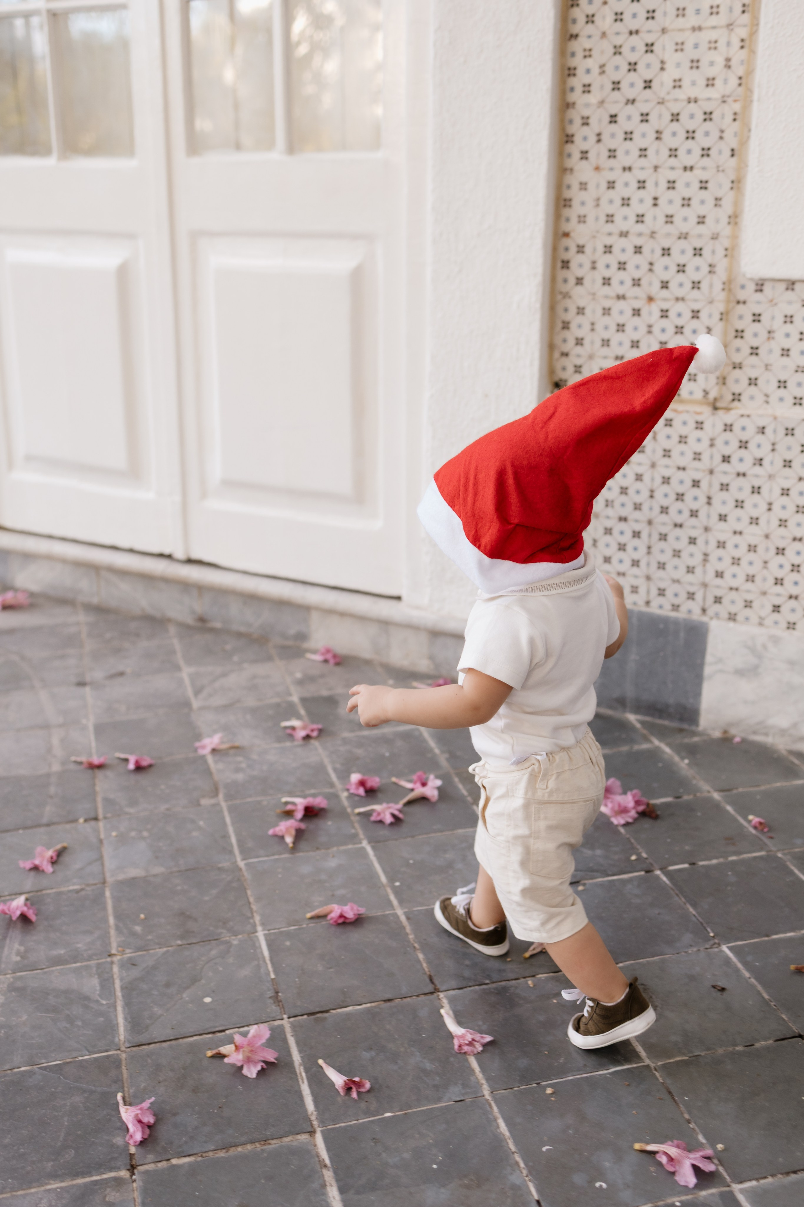 criança correndo com gorro do papai noel, sem mostrar os rosto