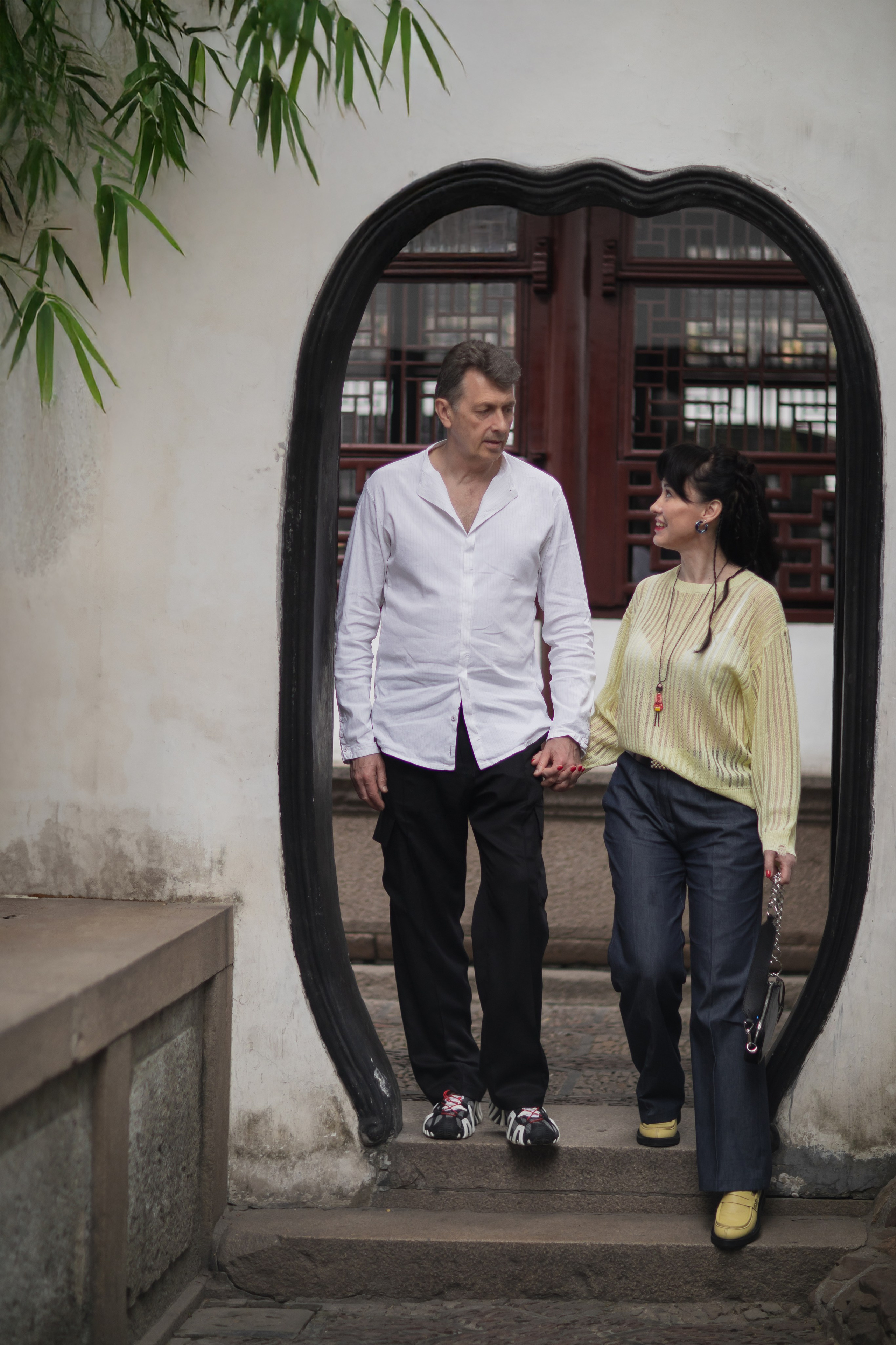 Пара в китайском саду Юй Юань среди традиционных павильонов и прудов