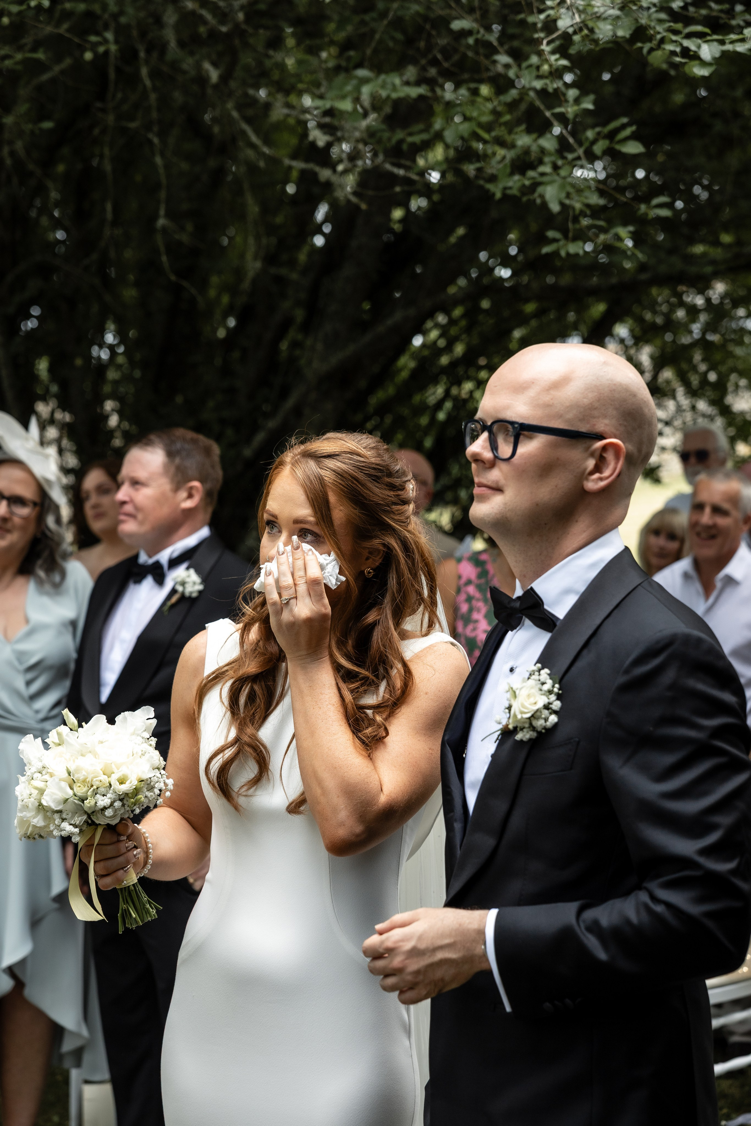Bride and groom laughing and crying with their guests after the ceremony