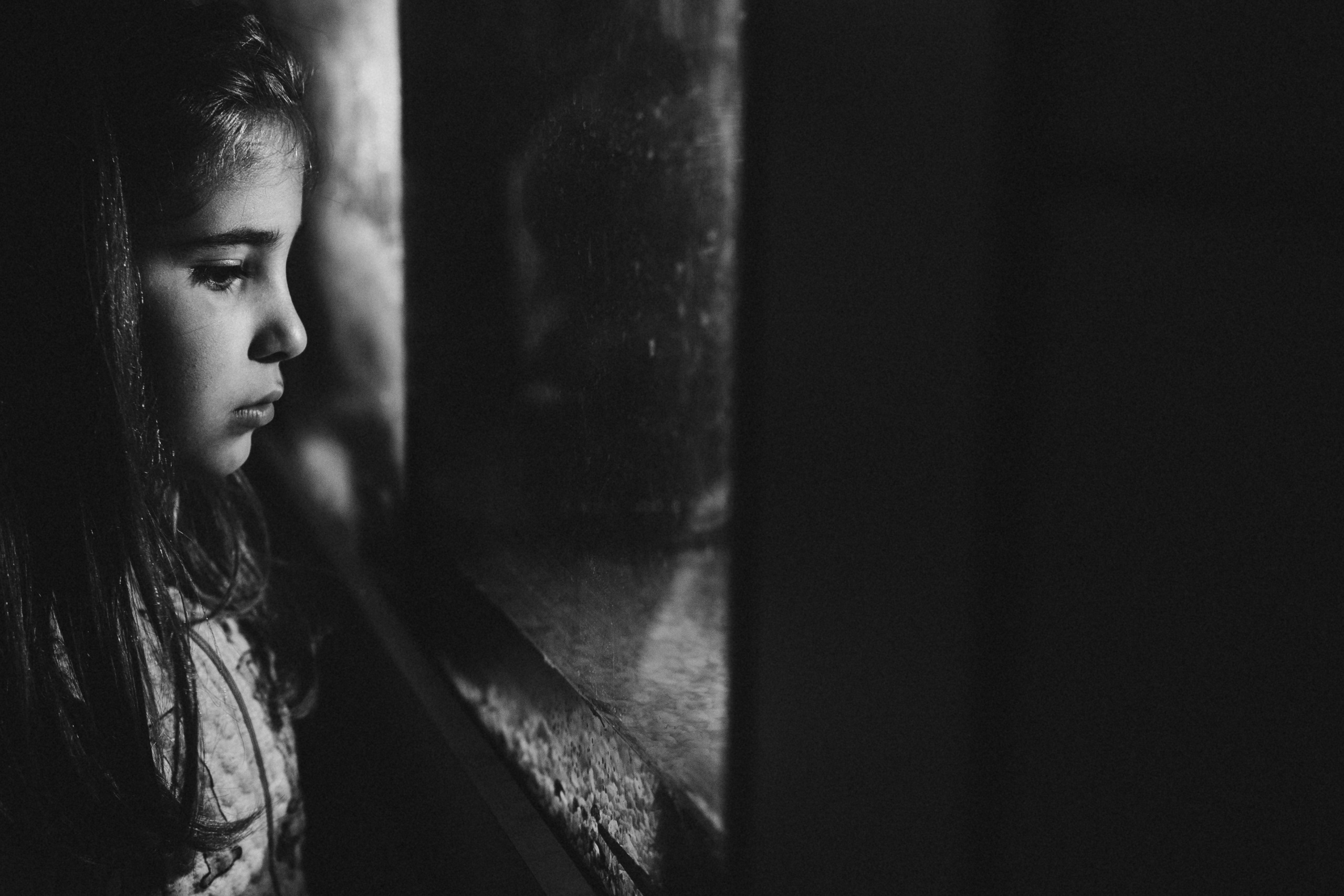 чёрно-белая  социальная фотография  «Доброе сердце» портрет девочка смотрит через стекло