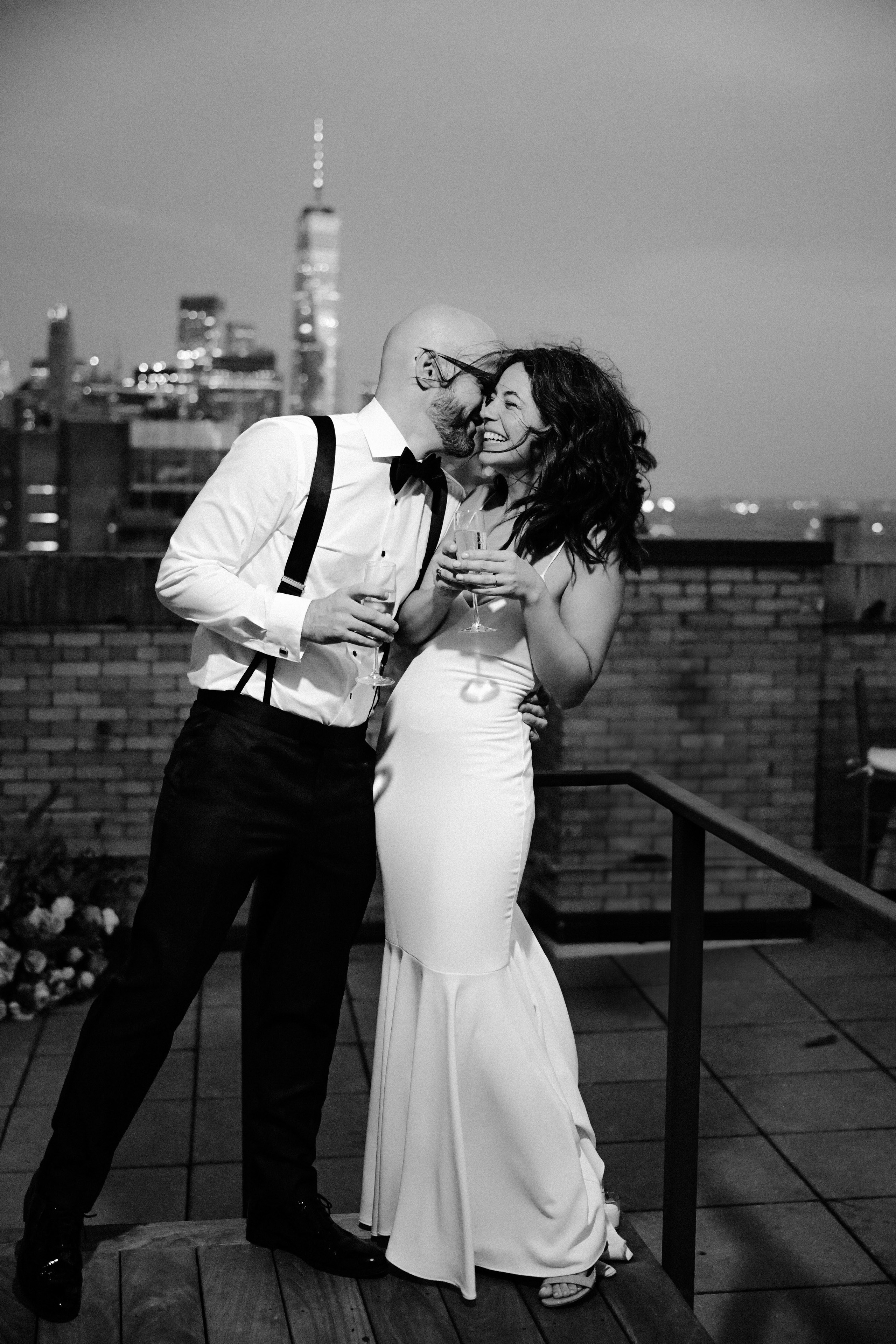 a man and woman are kissing on a rooftop