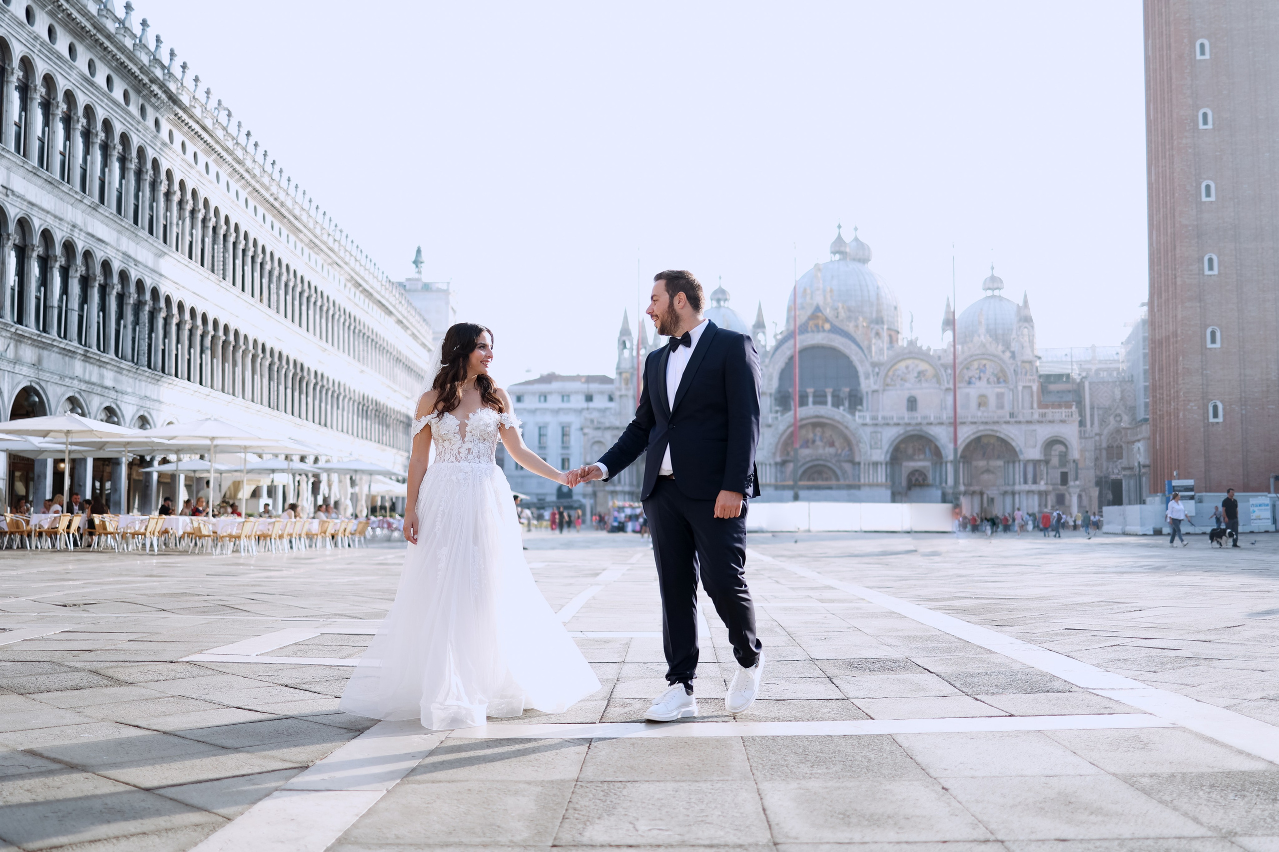the bride and groom walk throw San Marco square 