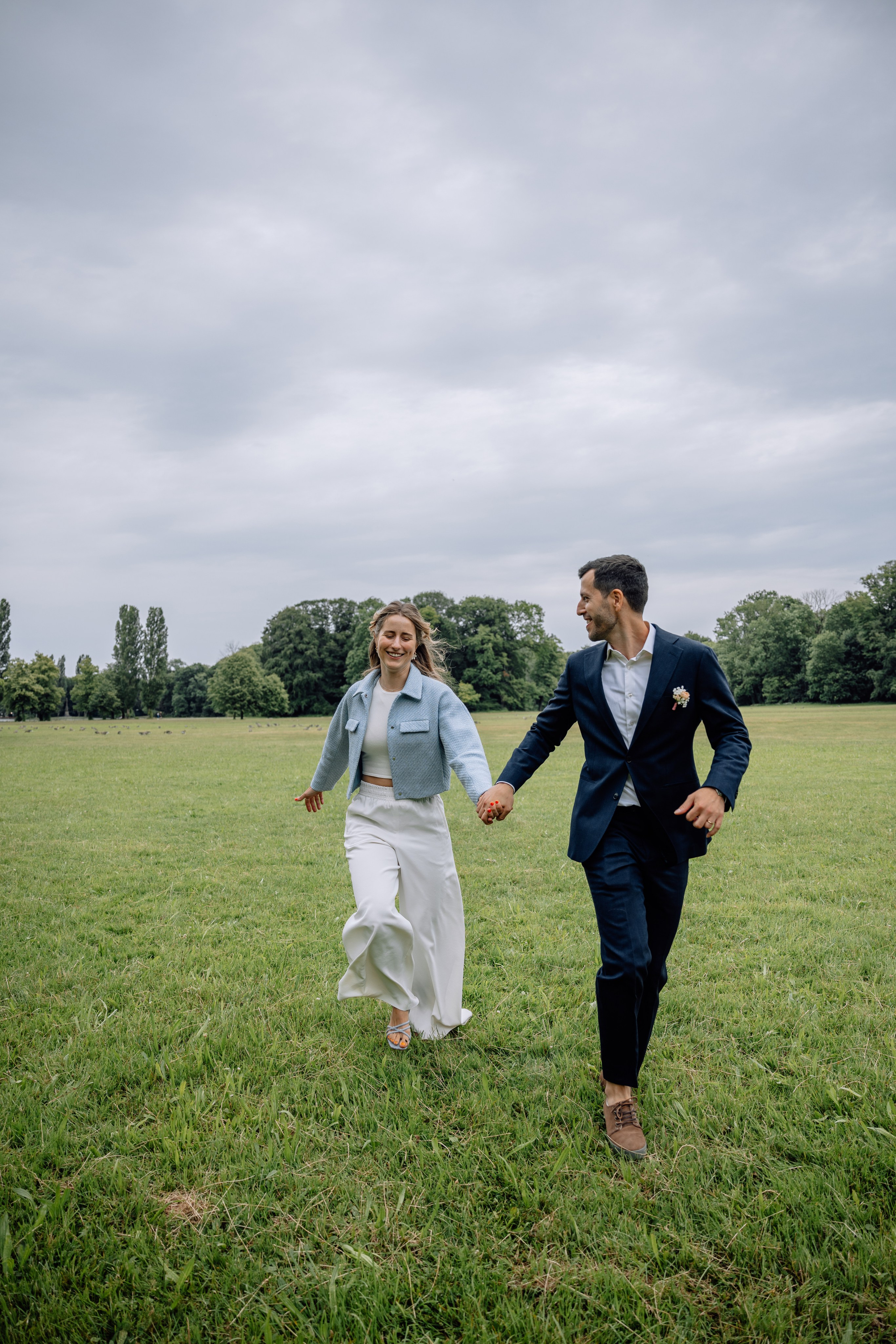 Braut und Bräutigam rennen im Park – glückliche, spontane Momente Mandlstraße 14