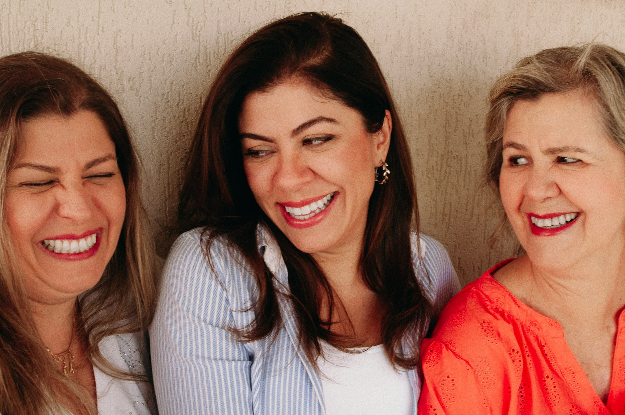 Ensaio de familia, mãe e filhas sorrindo.