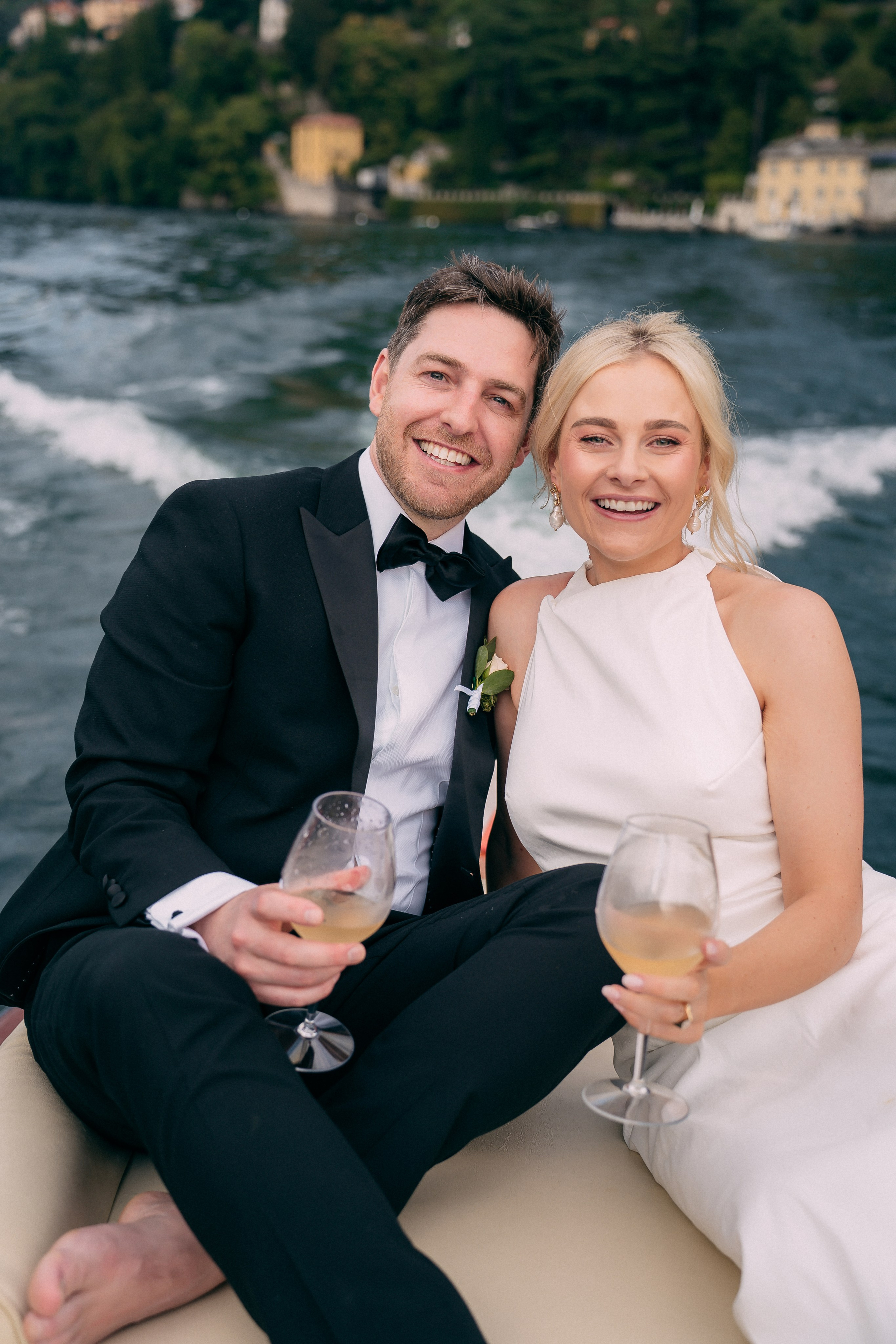 Bride and groom smiling together on the boat at Villa Lario, Lake Como, Italy