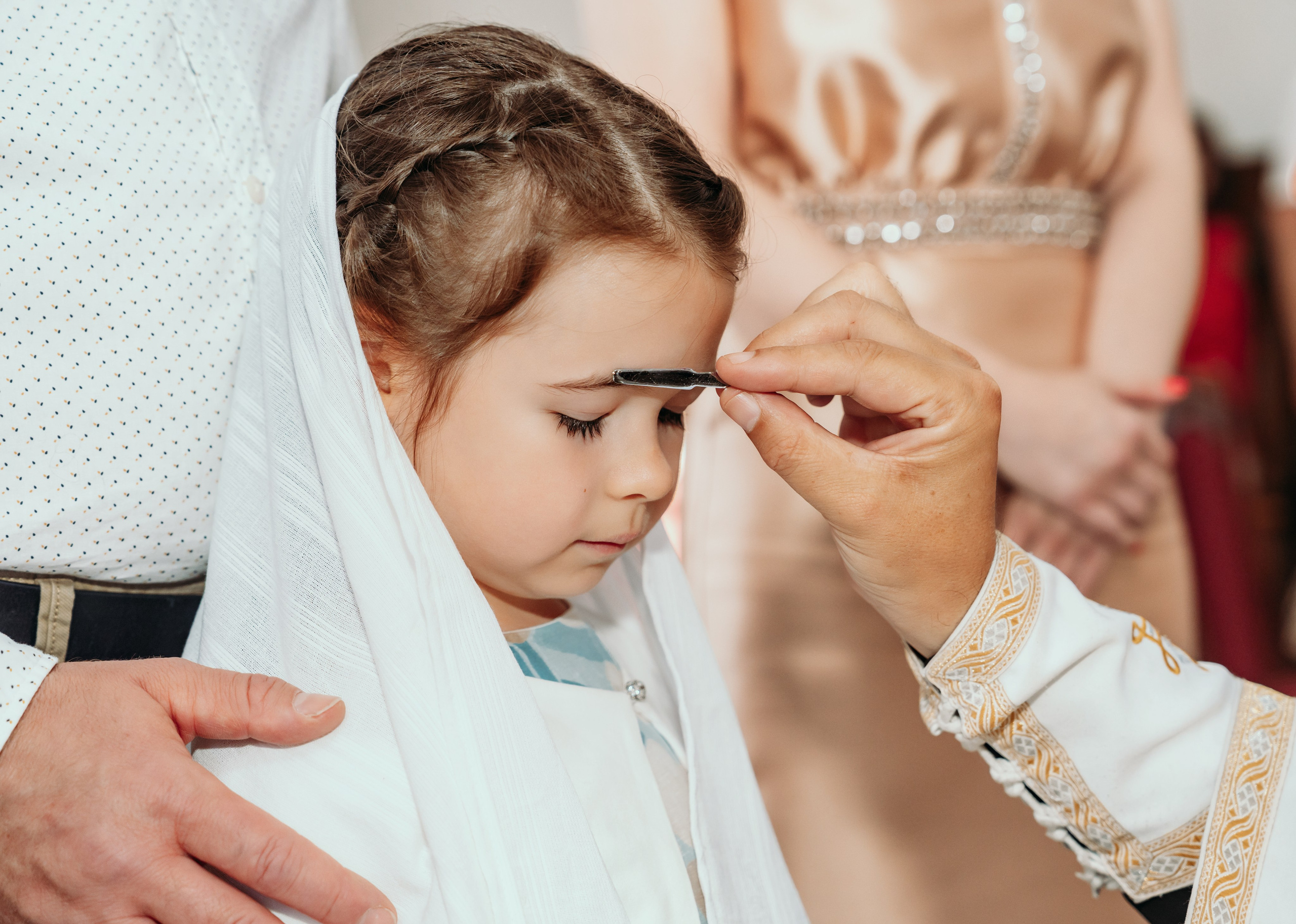 Sveštenik blagosilja porodicu tokom krštenja