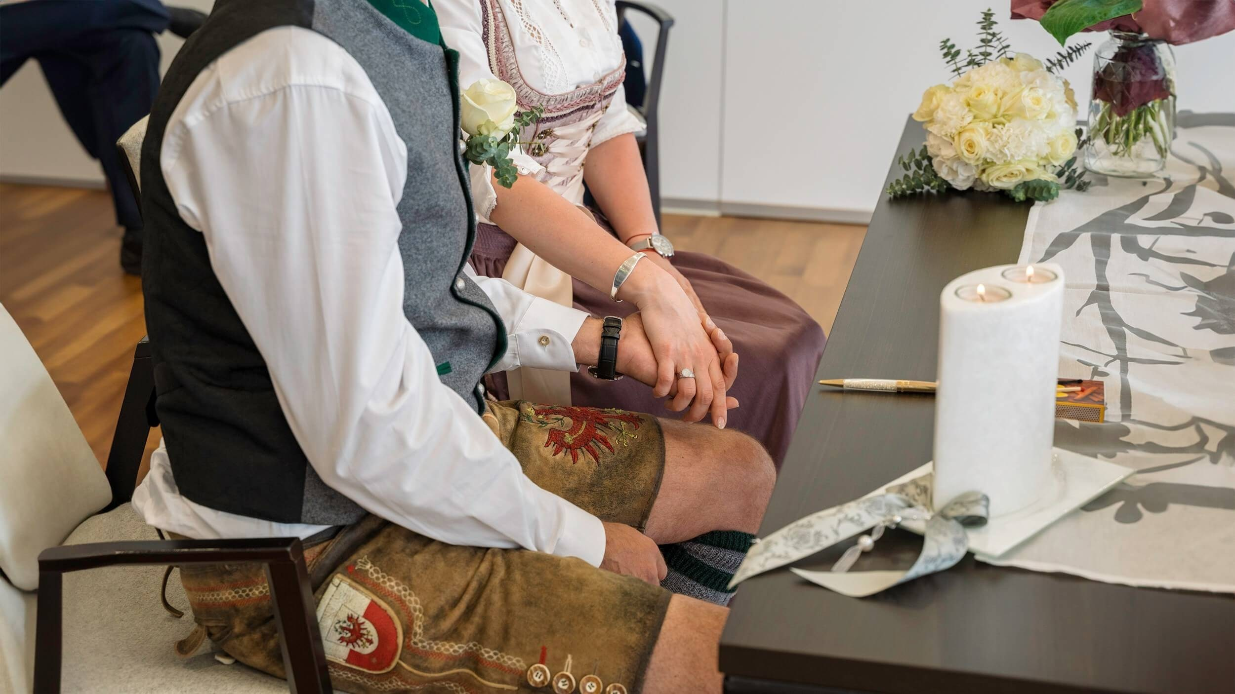 Gäste und Brautpaar im festlich geschmückten Standesamt Sölden bei der standesamtlichen Trauung.