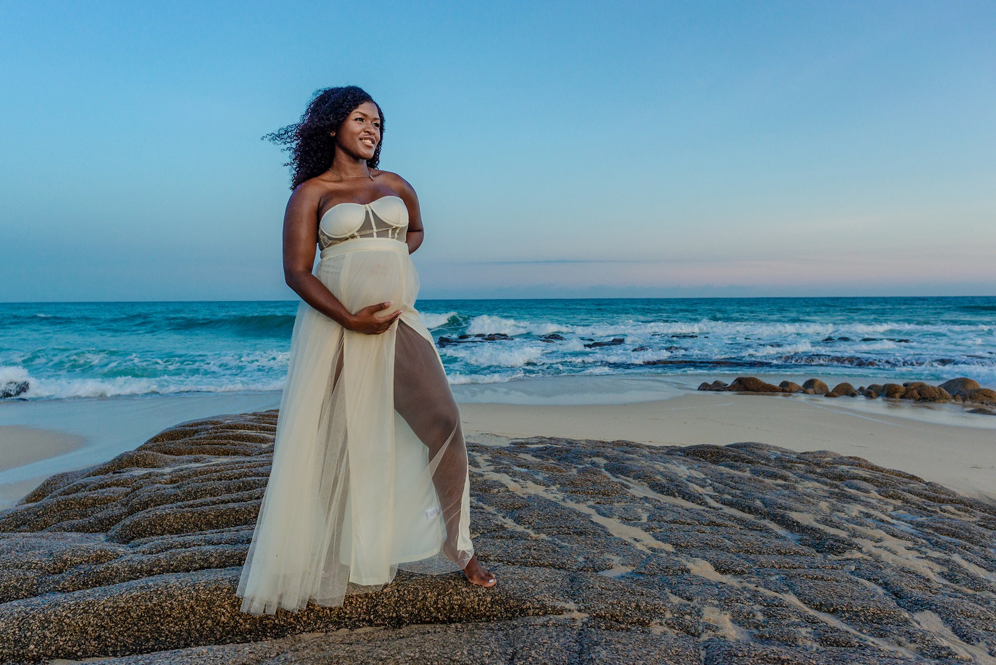 Expecting mother portrait in Los Cabos – glowing maternity session with soft light, ocean waves, and desert coastline, symbolizing the beauty of waiting for new life.