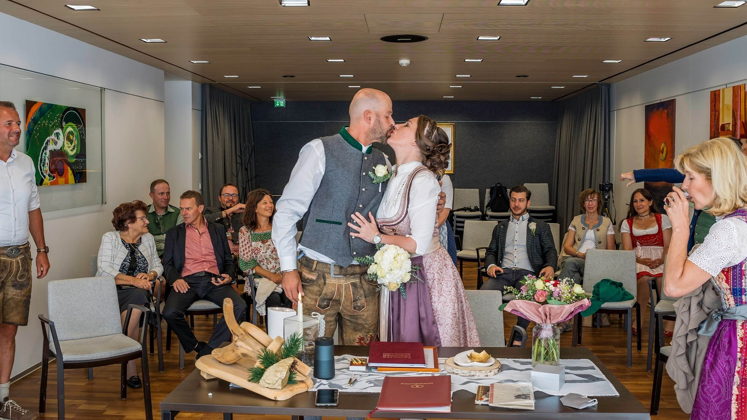 Gäste und Brautpaar im festlich geschmückten Standesamt Sölden bei der standesamtlichen Trauung.