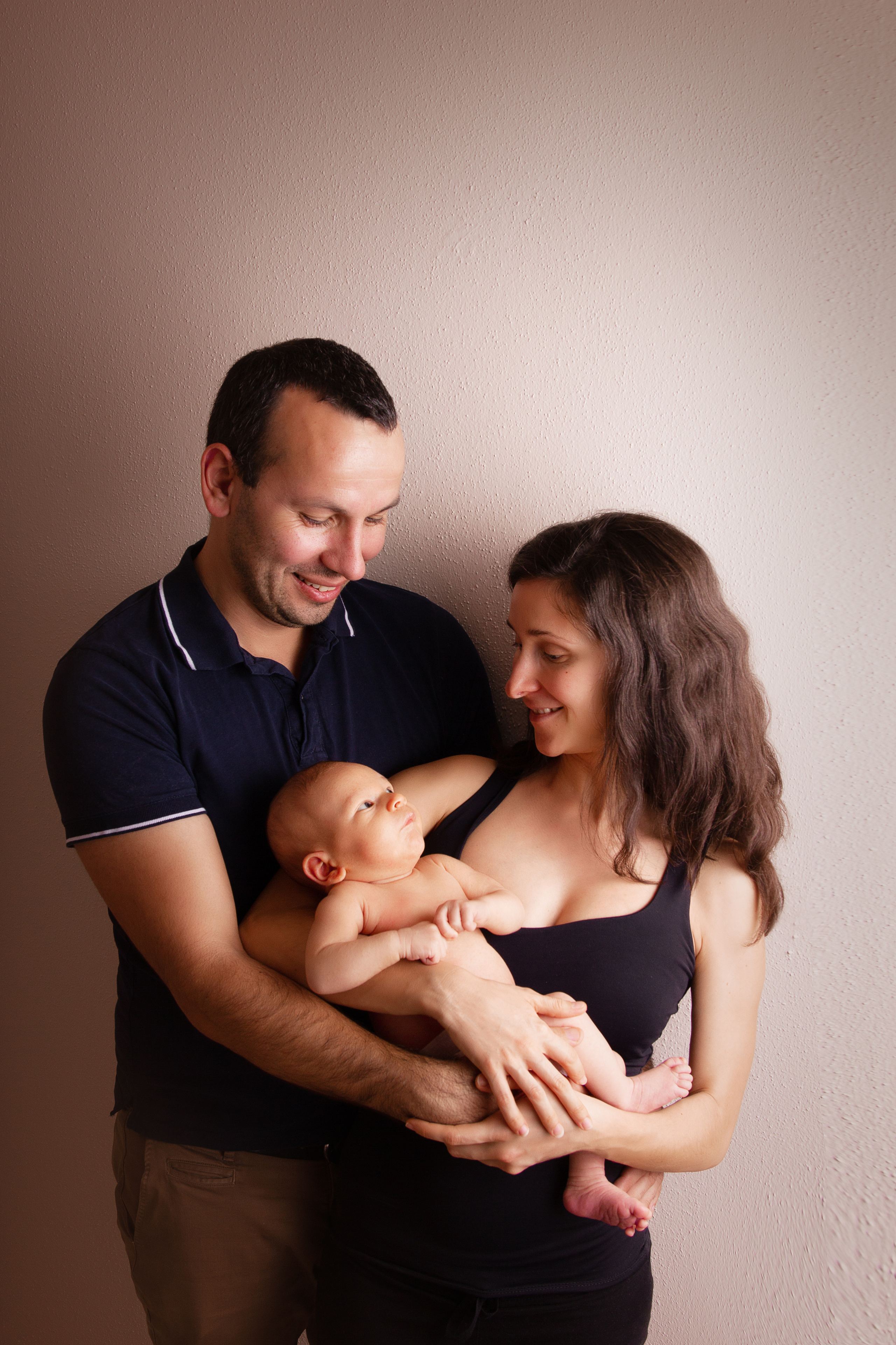 Neugeborenes in den Armen der Eltern