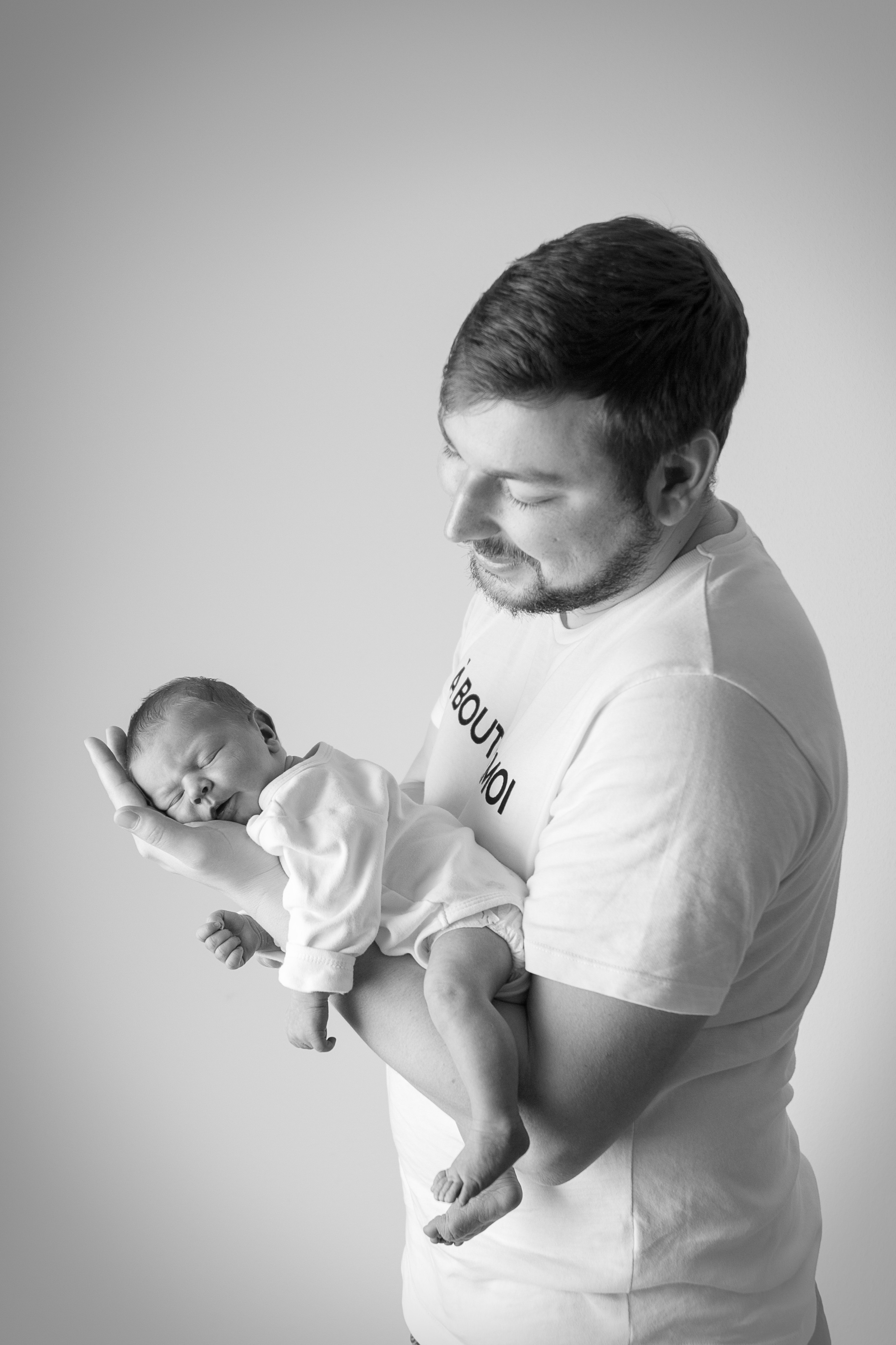 Auf einem Schwarzweißfoto hält Papa sein erstes Kind sanft und liebevoll in den Armen