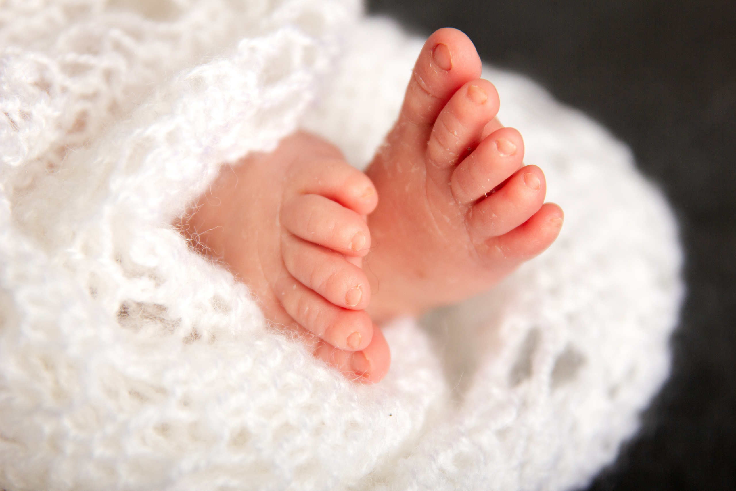 Babyfüüße in eine weiiße Decke gewickelt