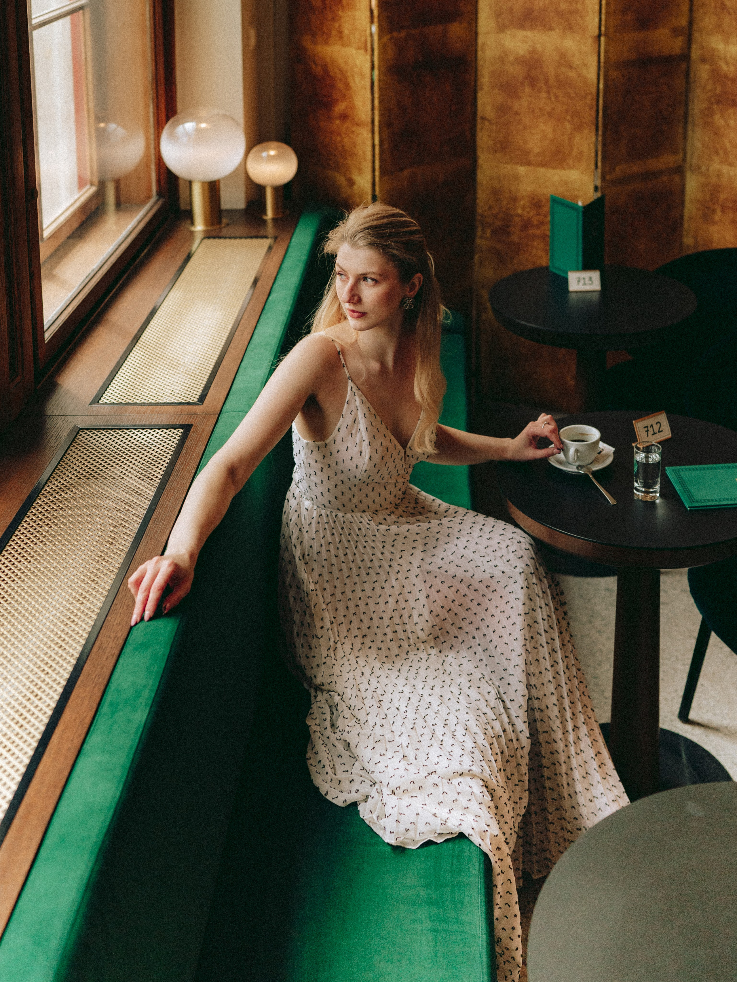Woman enjoying coffee in a historic Viennese café during a cinematic photoshoot