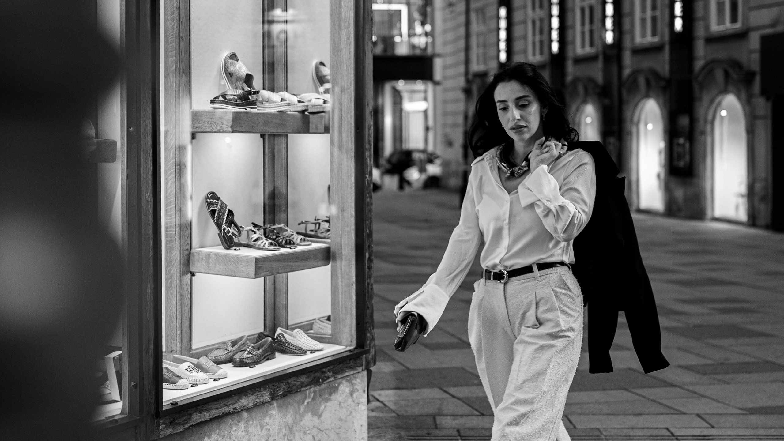 Cinematic black and white portrait of a woman walking through Vienna in the evening