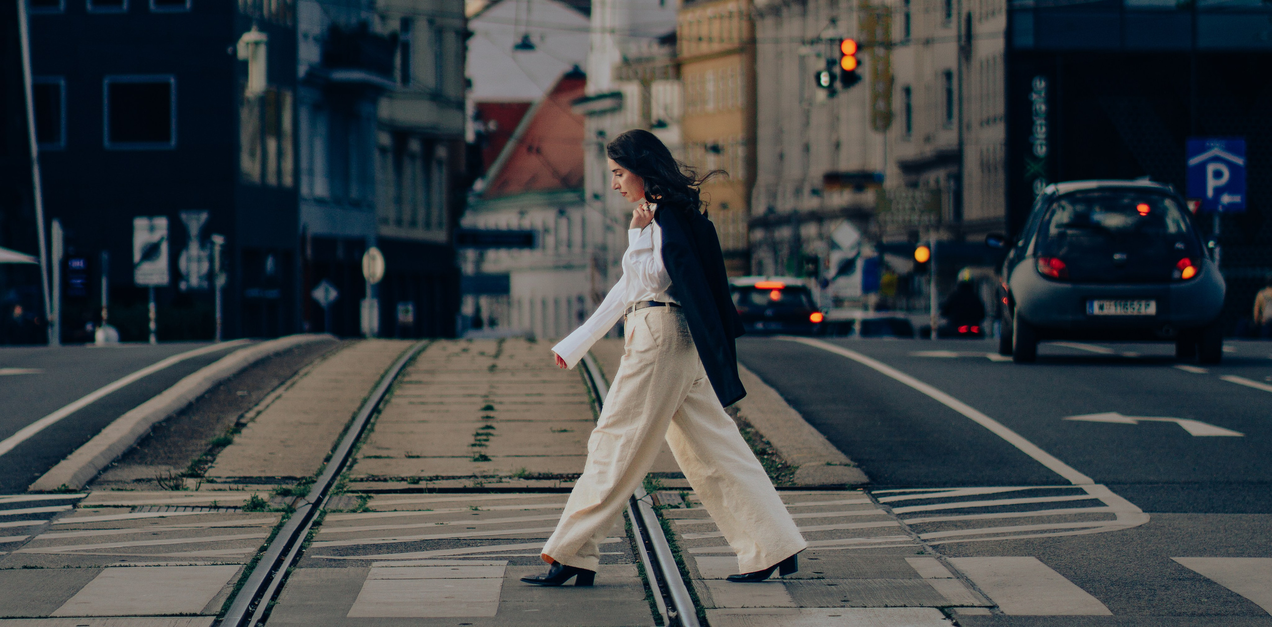 Woman crossing tram tracks during a cinematic photoshoot in Vienna