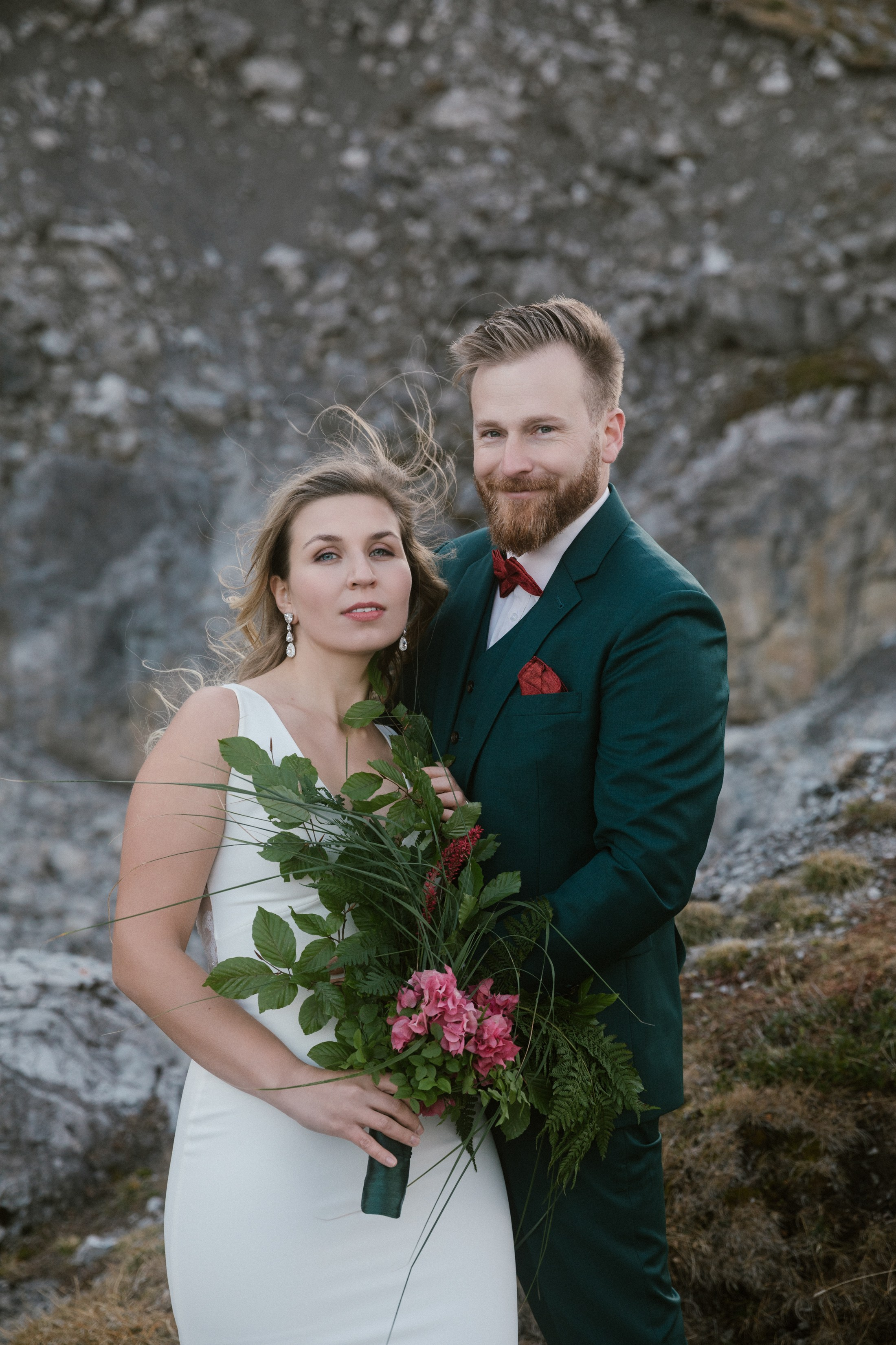 Hochzeitspaar im grünen Anzug und Kleid am Lünersee in den Alpen