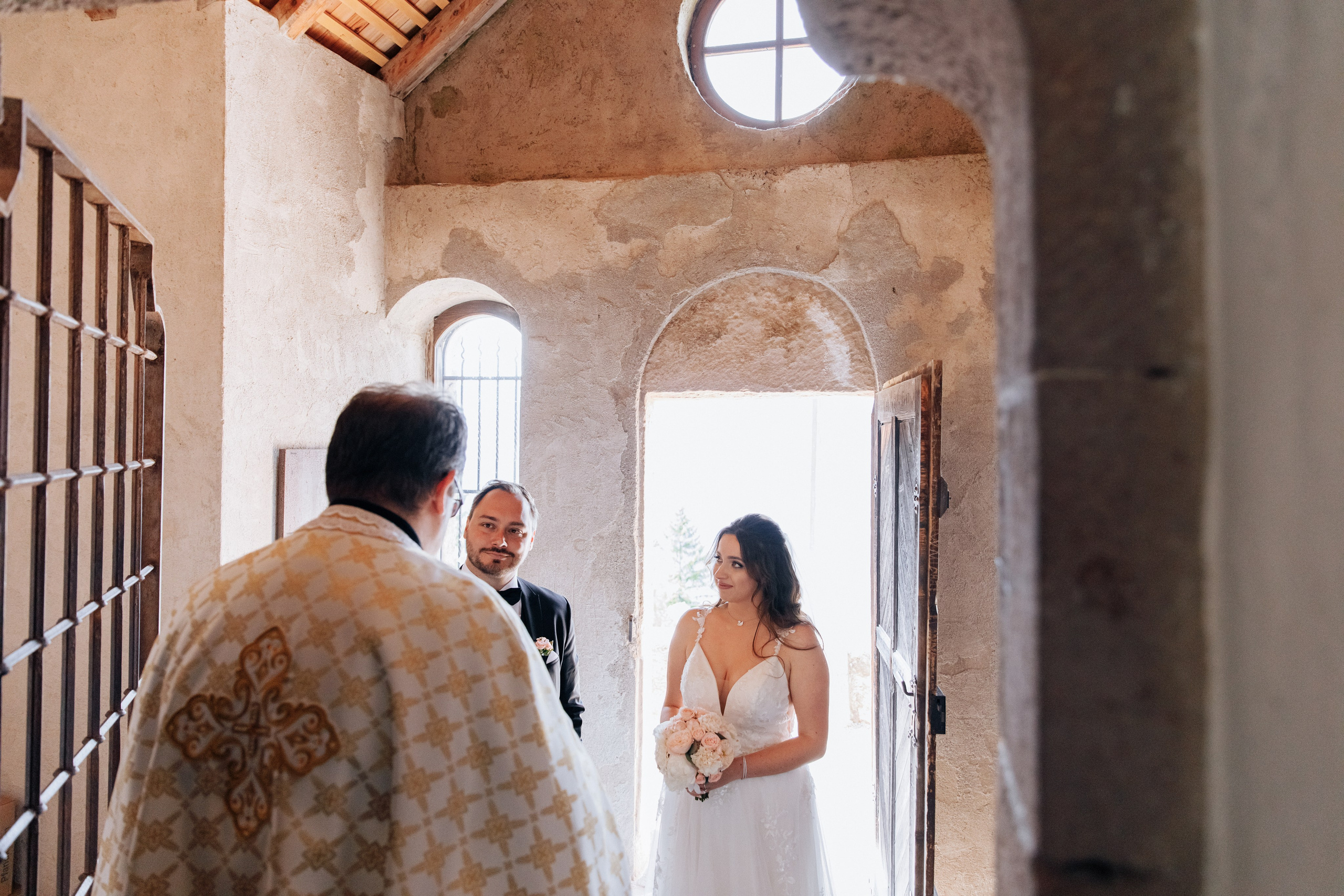 Der Priester spricht mit dem Brautpaar während der Hochzeitszeremonie, ein feierlicher Moment der Trauung.
